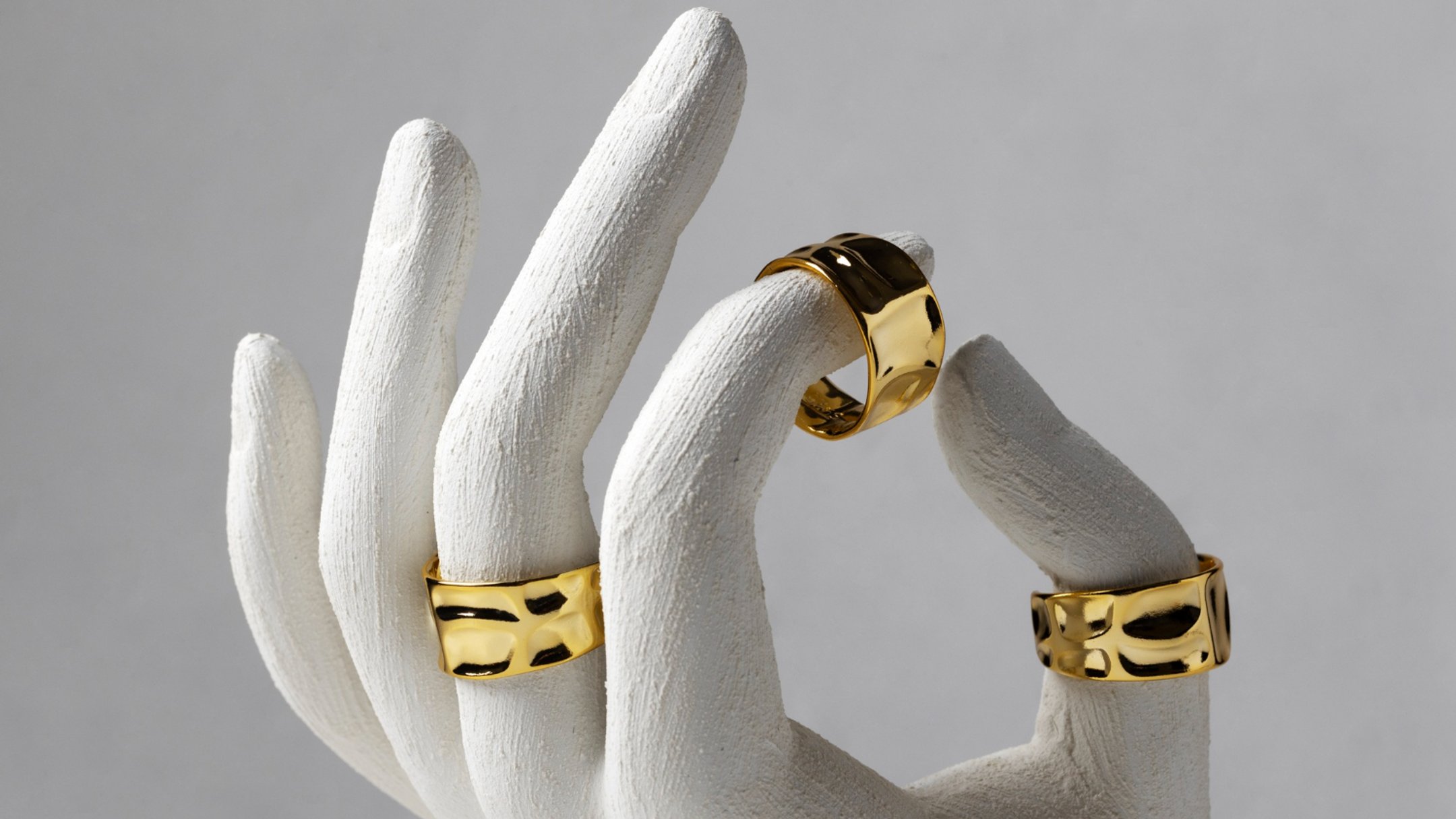 Gold rings on a sculpted hand