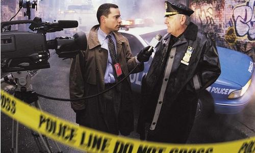 A reporter interviewing a police officer on a crime scene