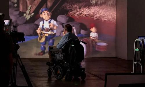 A wheelchair user watching a film on a projector
