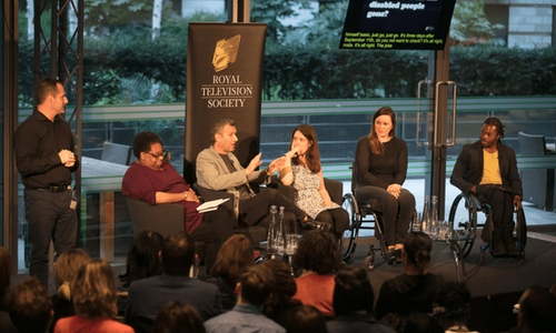 A panel of people on stage at a conference