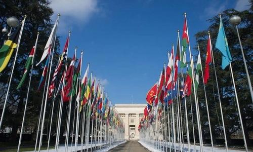 Flag poles lead to the entrance of a building