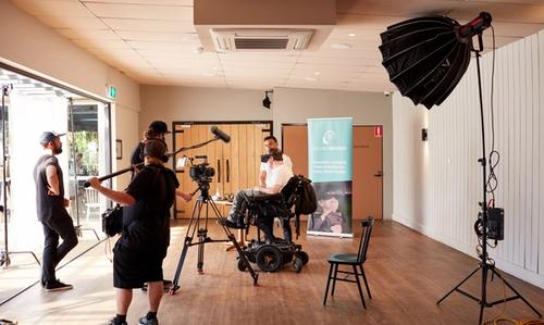 A film crew filming a wheelchair user at work