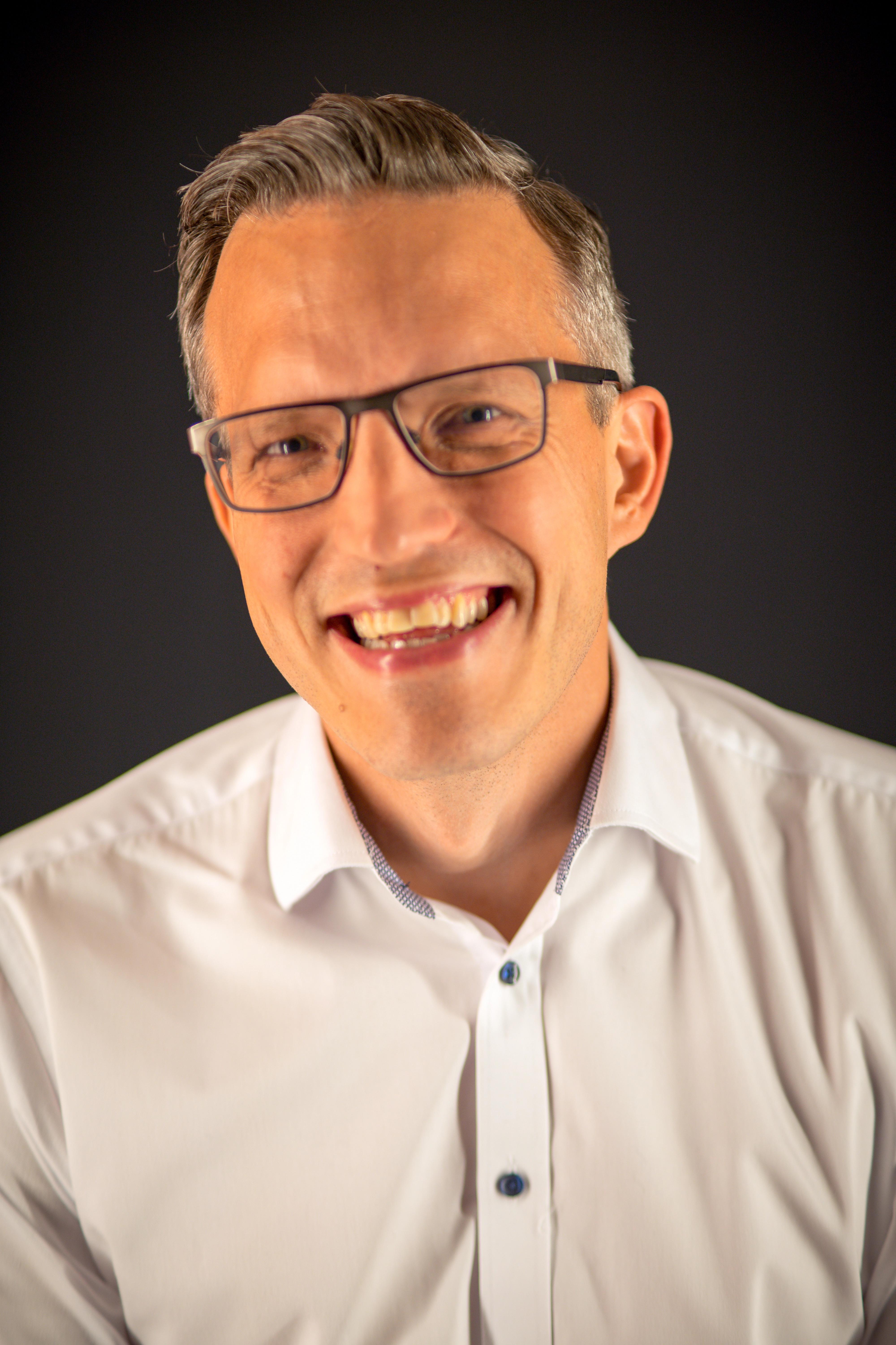 Smiling man with glasses.