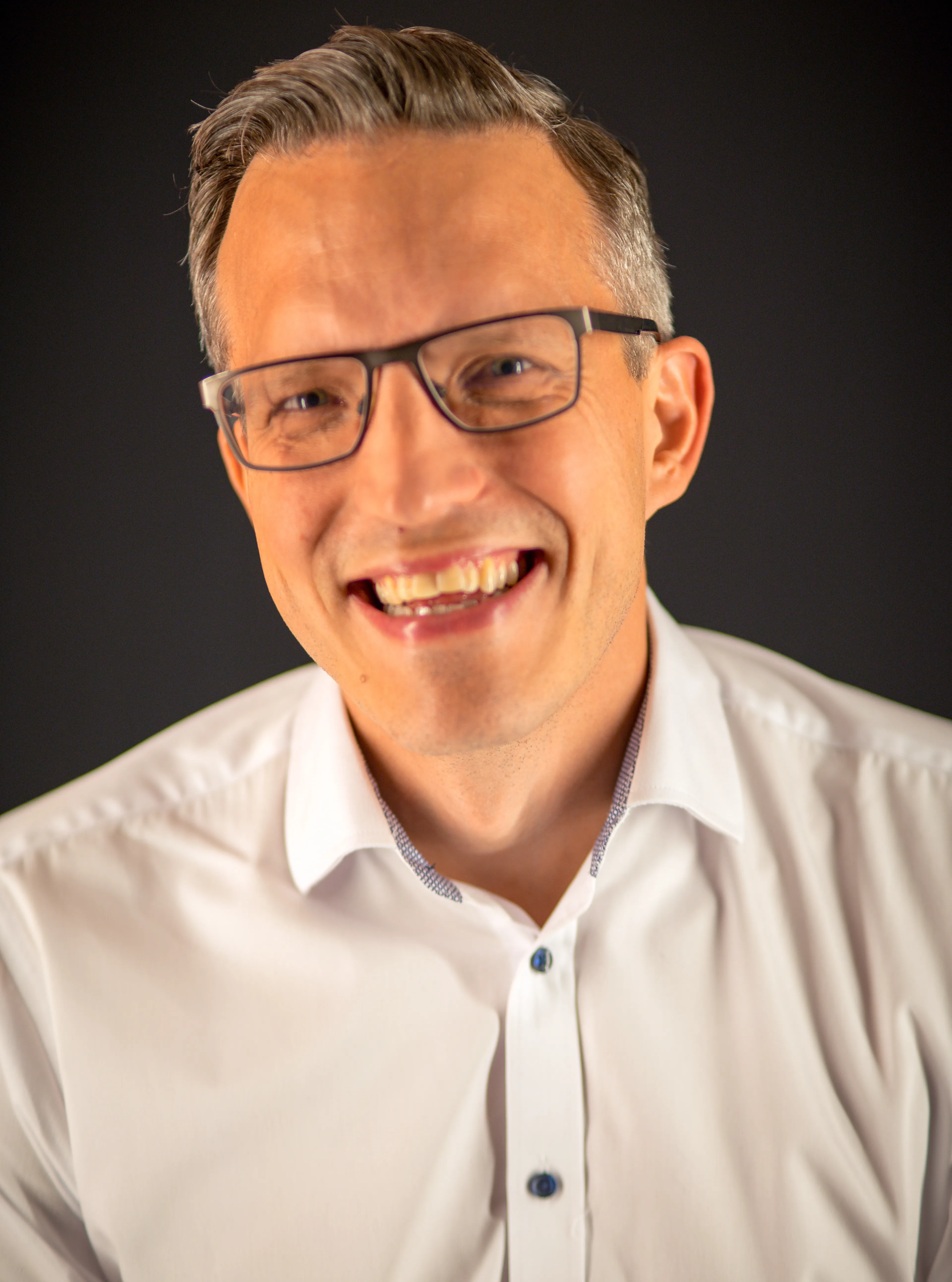 Smiling man with glasses.