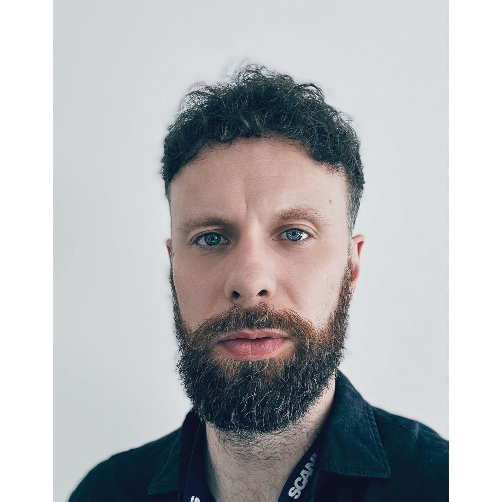 Man with a beard wearing a black shirt.
