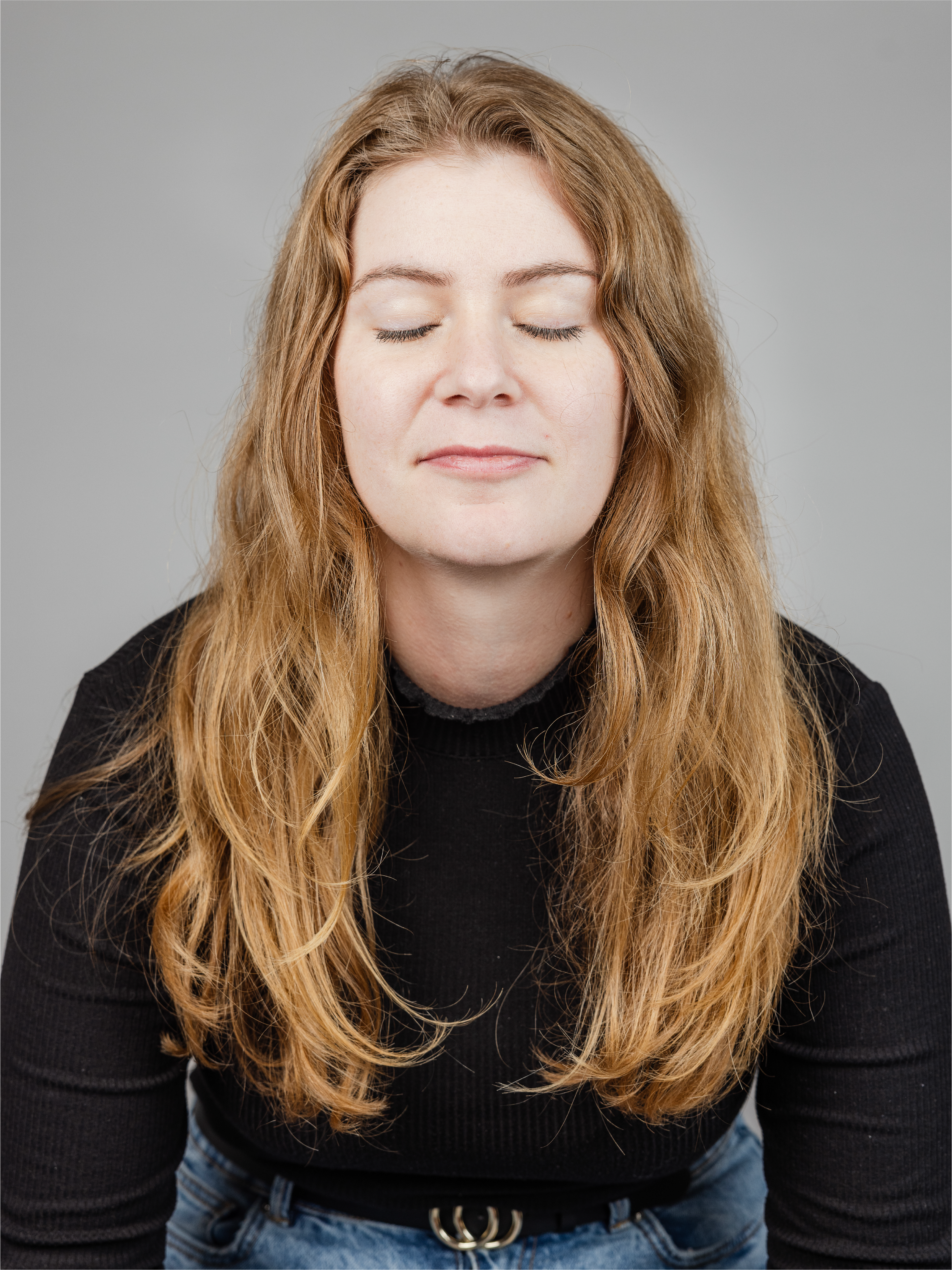 A woman with long red hair and closed eyes