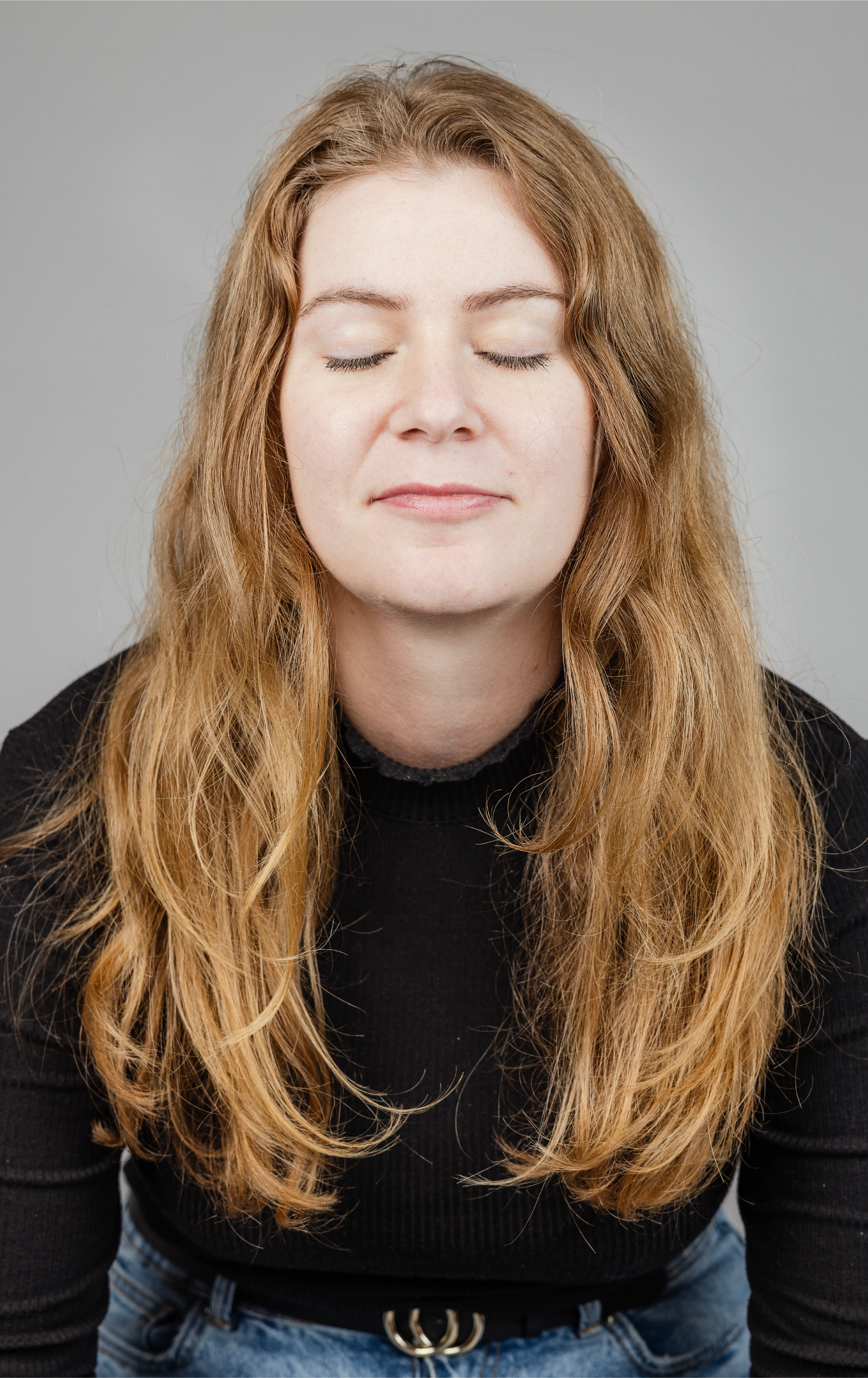 A woman with long red hair and closed eyes