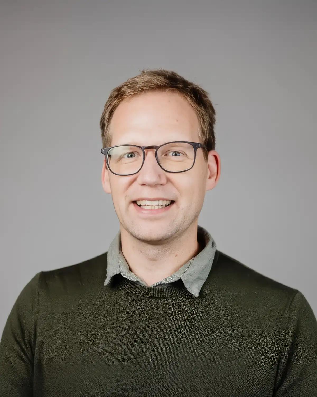 Man with glasses wearing a dark pullover