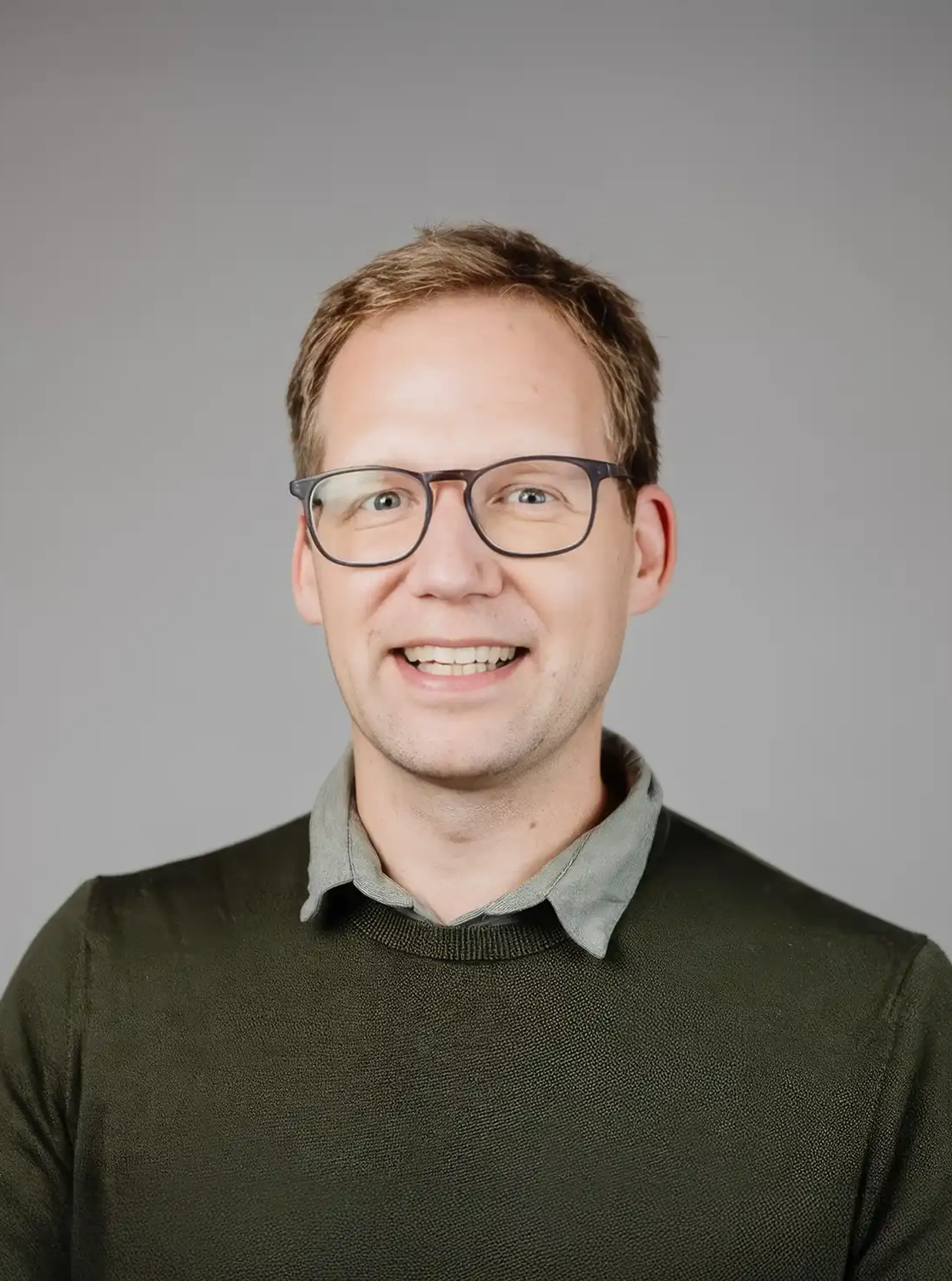 Man with glasses wearing a dark pullover