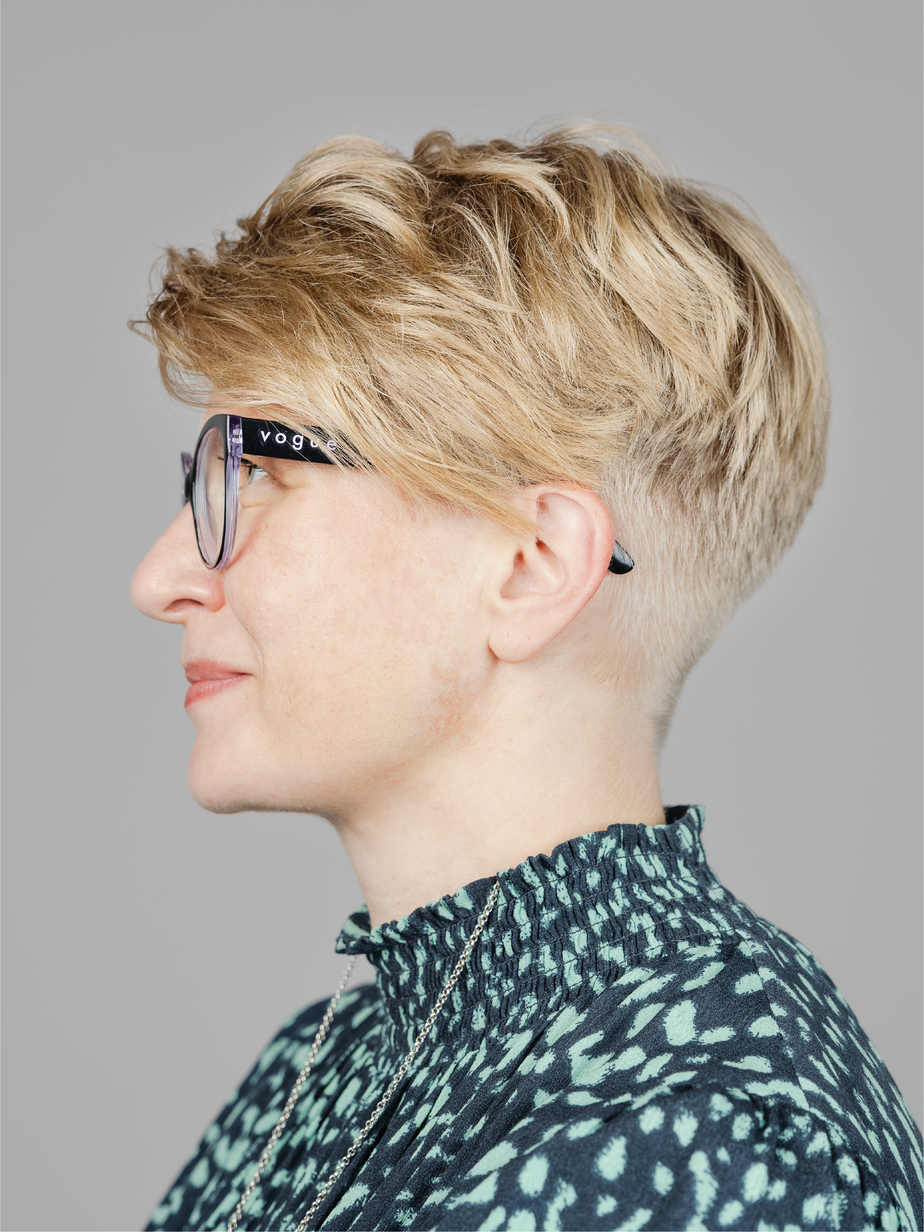 Woman with glasses and short hair facing the left