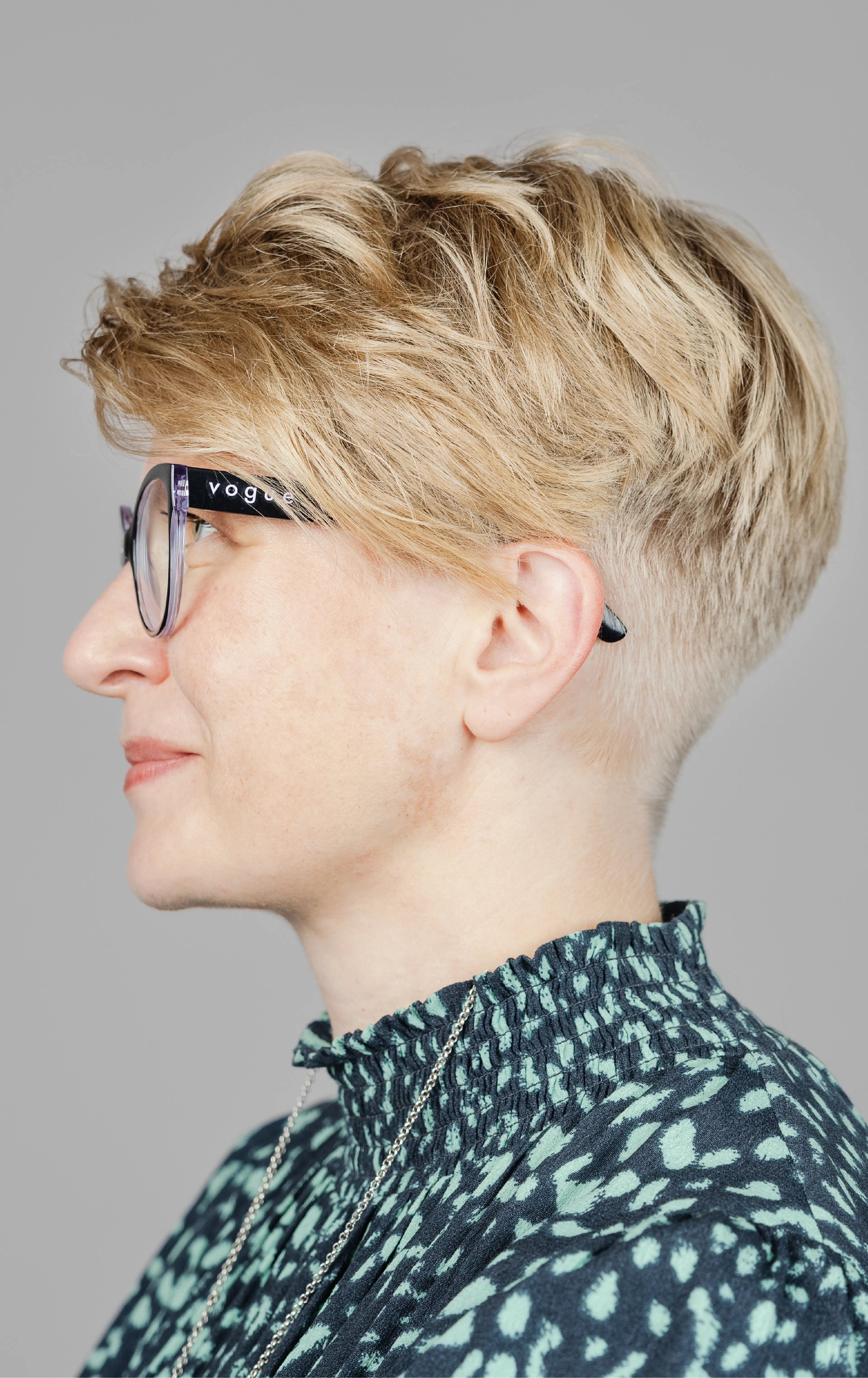 Woman with glasses and short hair facing the left