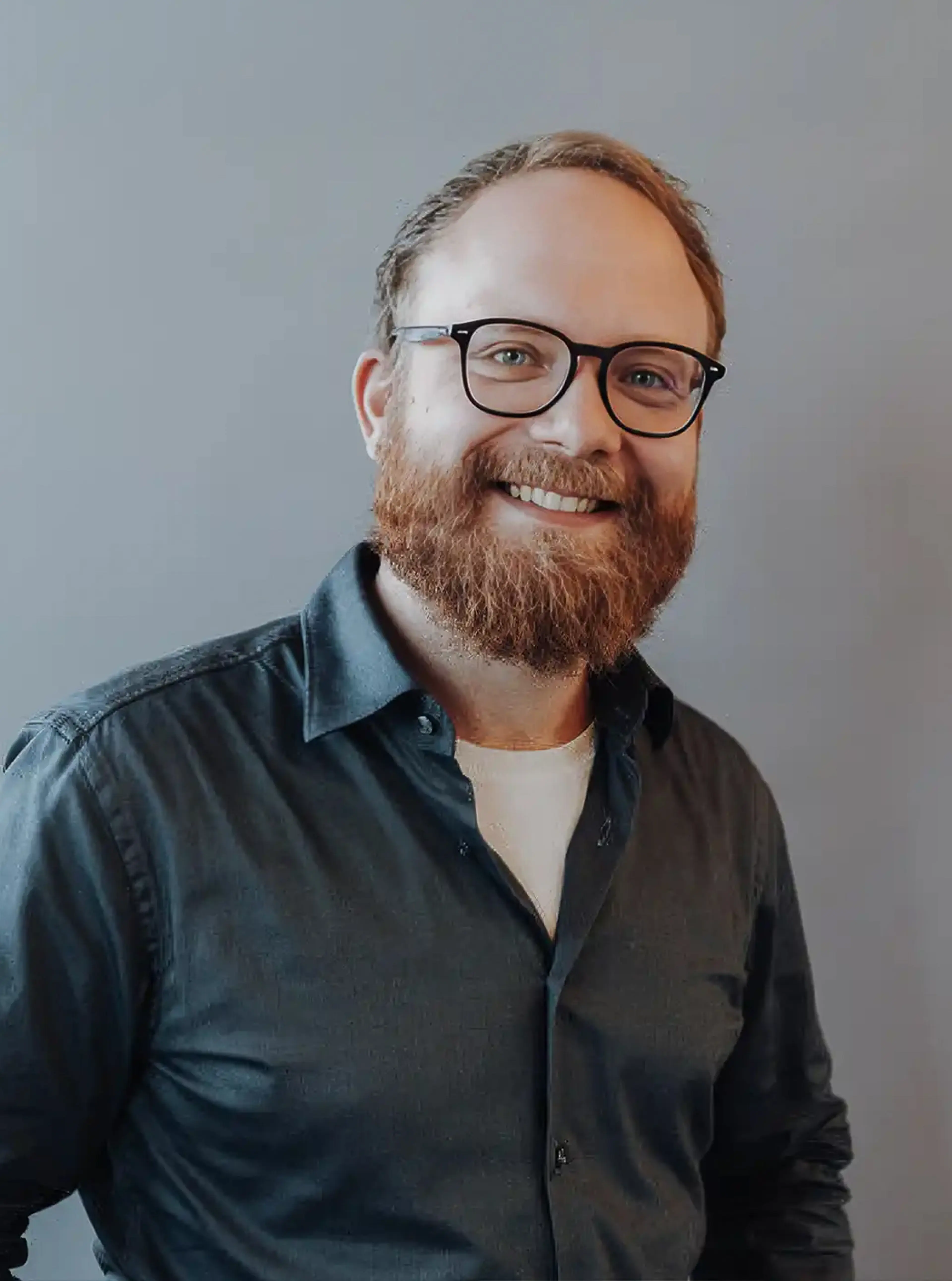 Man with glasses wears dark shirt