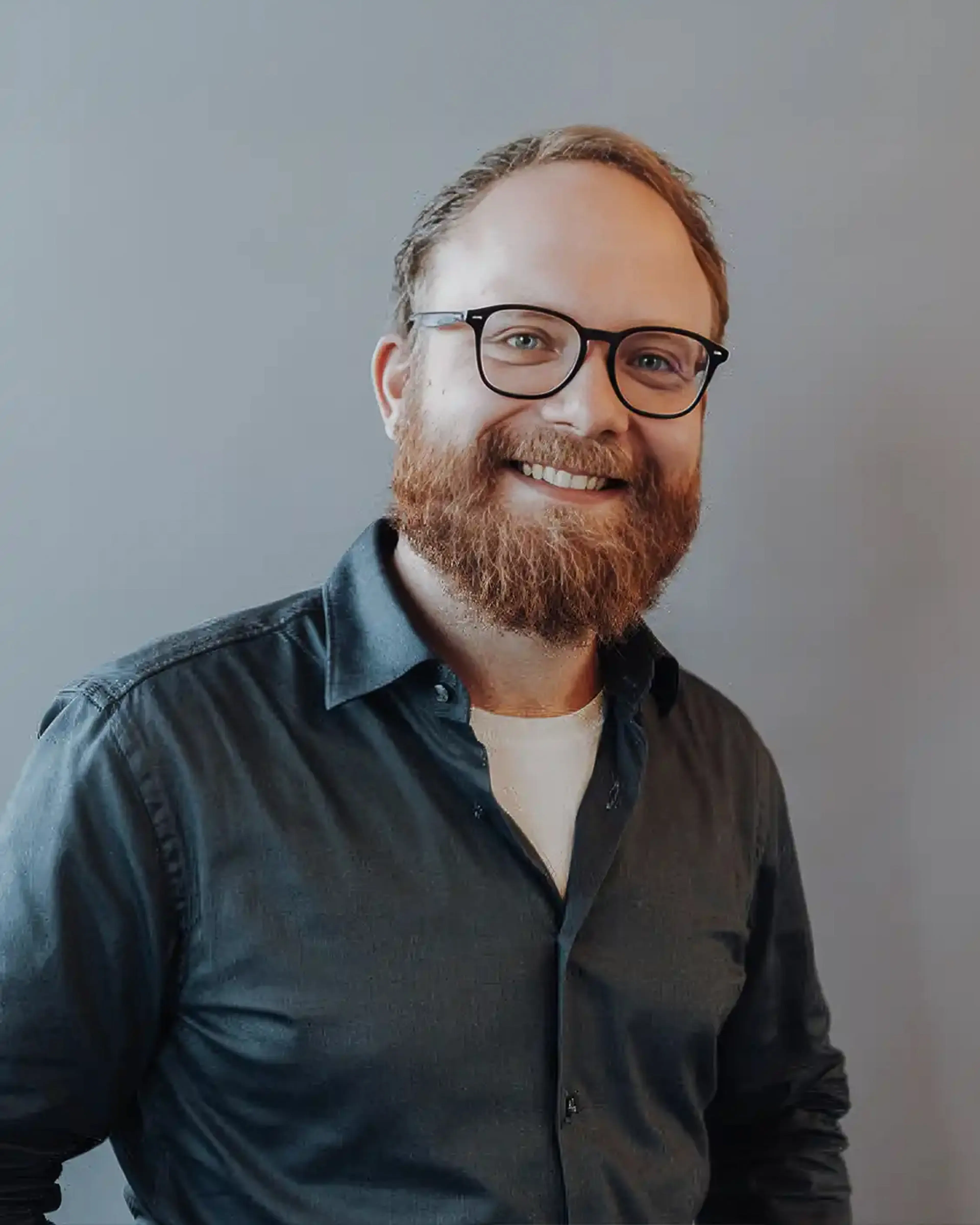 Man with glasses wears dark shirt