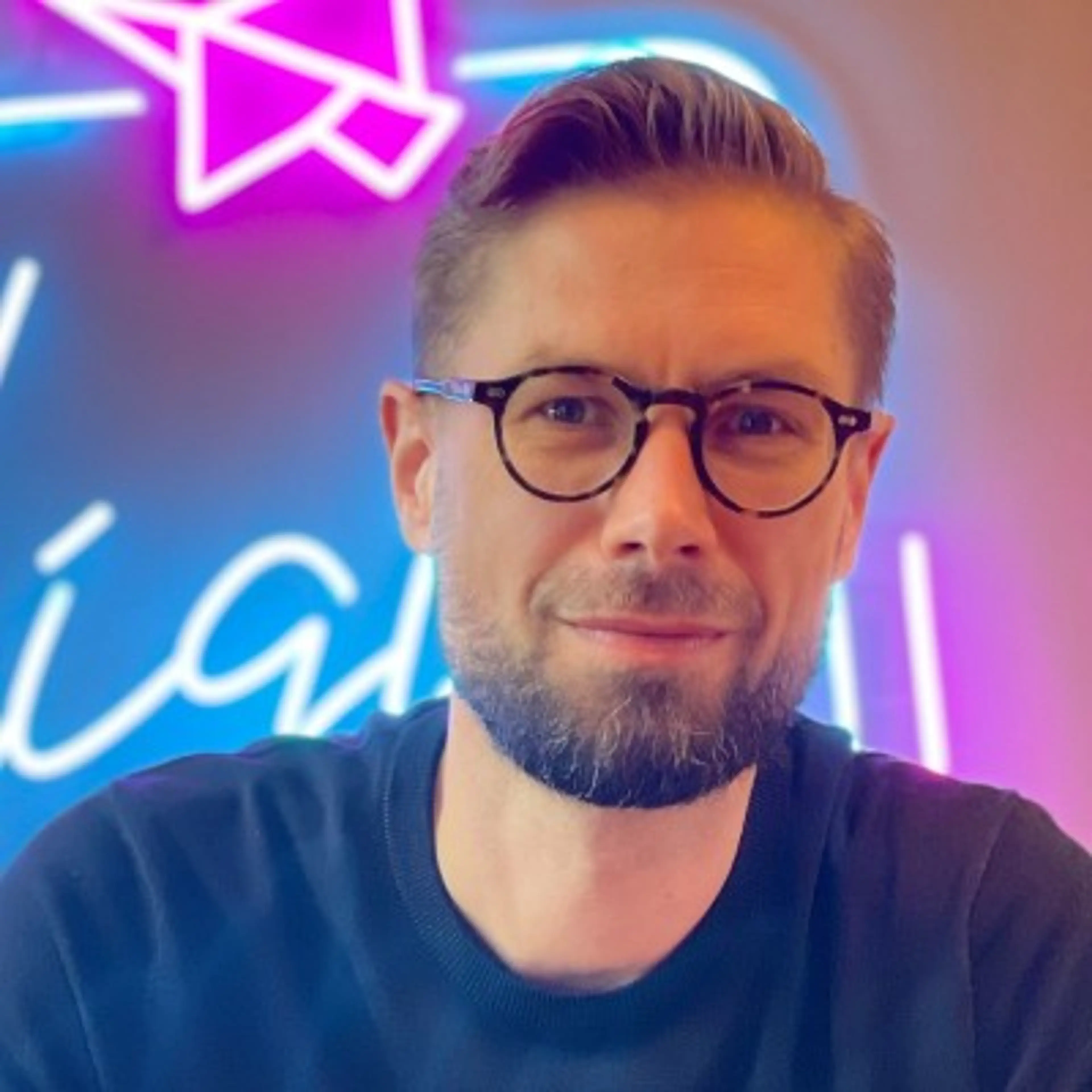 Man with glasses wearing black shirt
