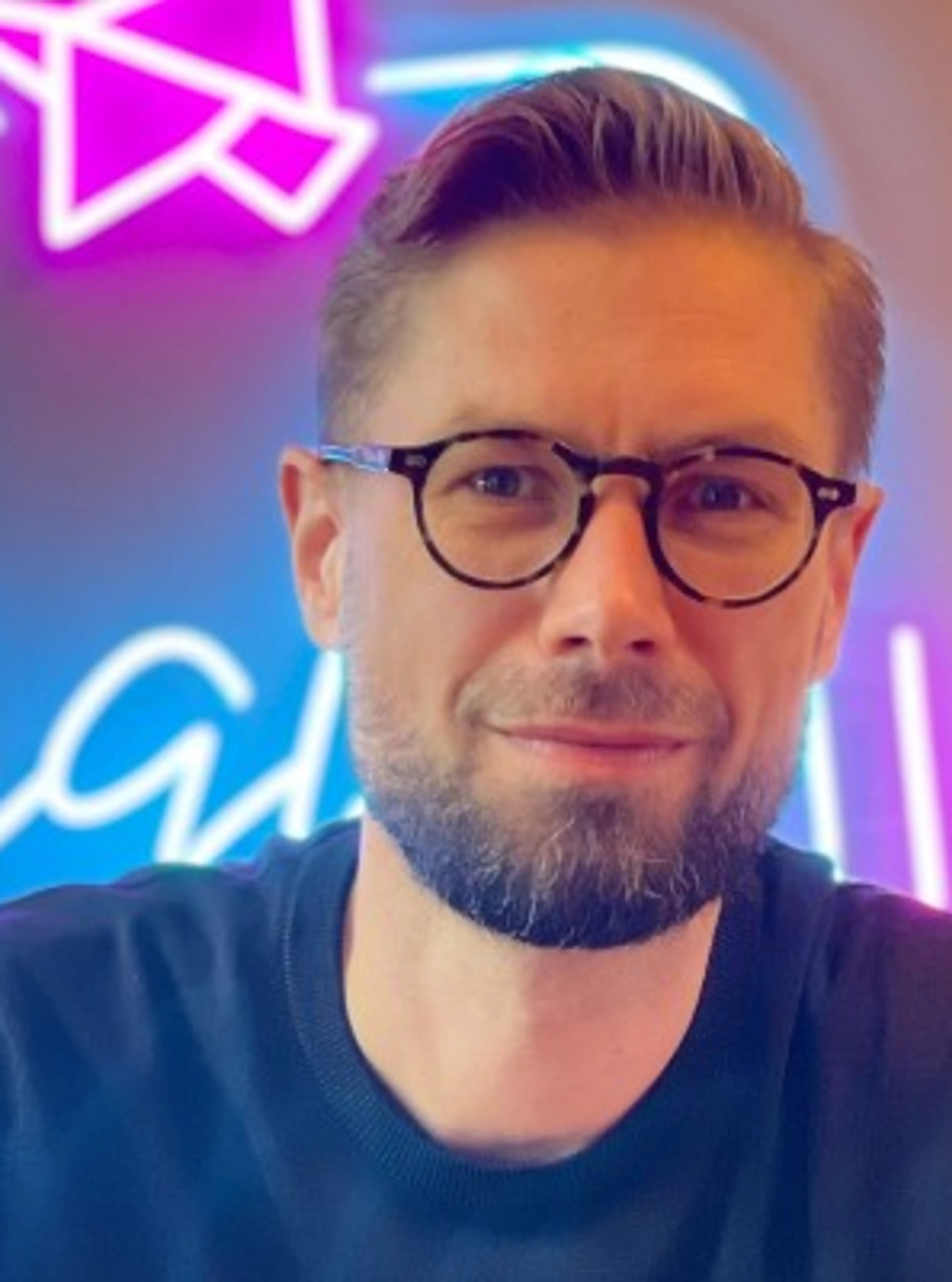 Man with glasses wearing black shirt