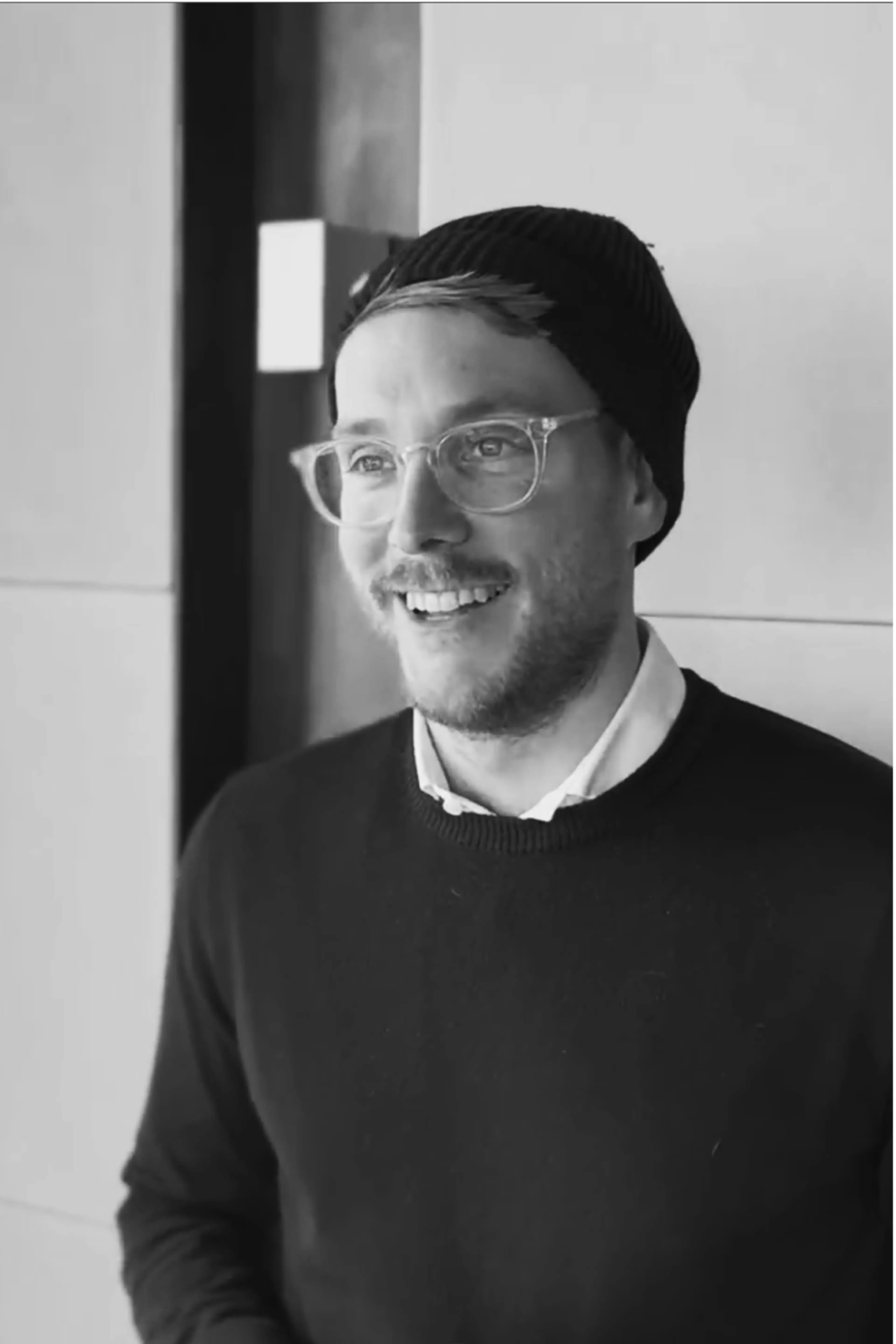 Man with glasses and beanie in black and white