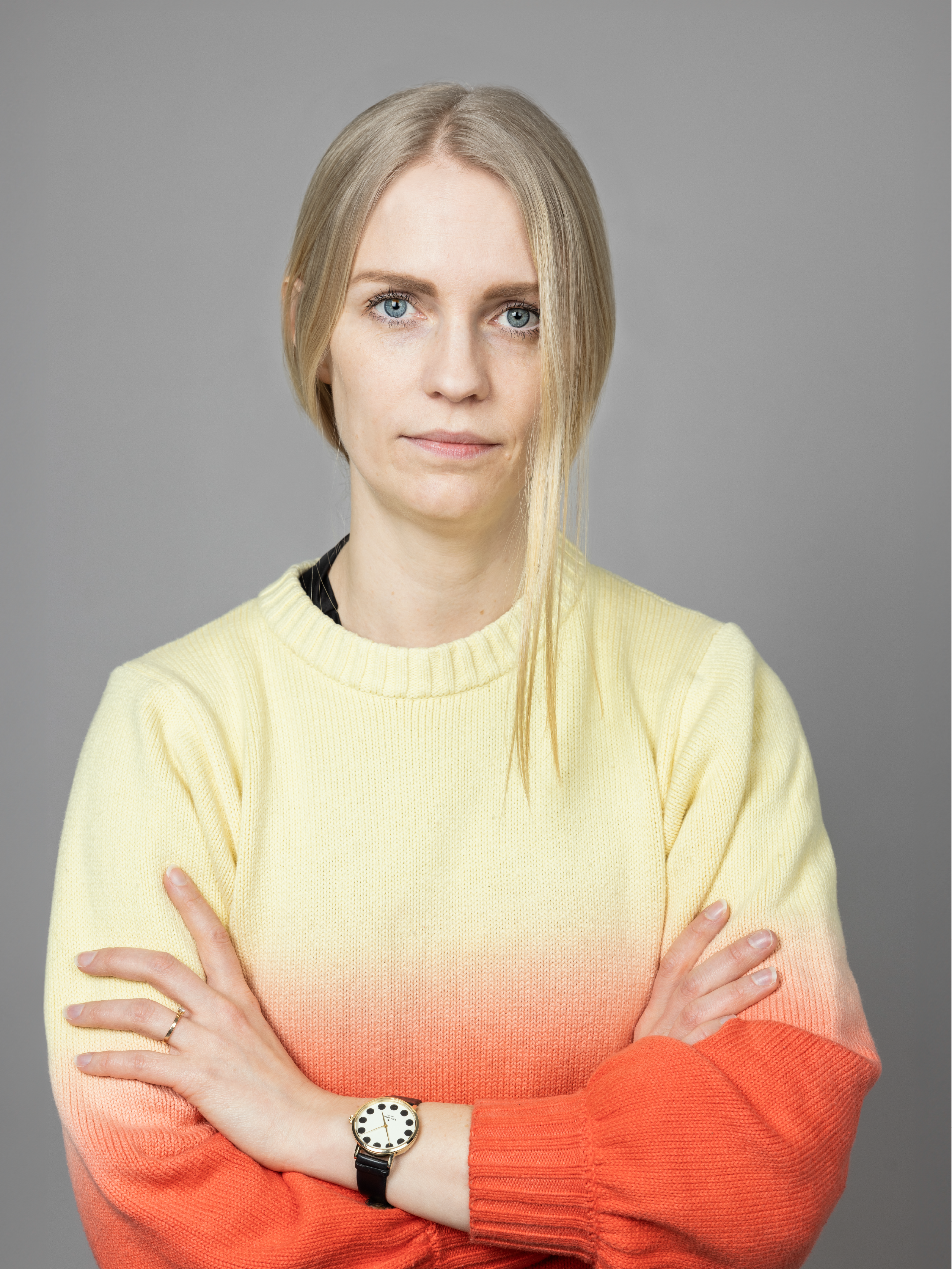 Woman in orange and yellow shirt with crossed arms