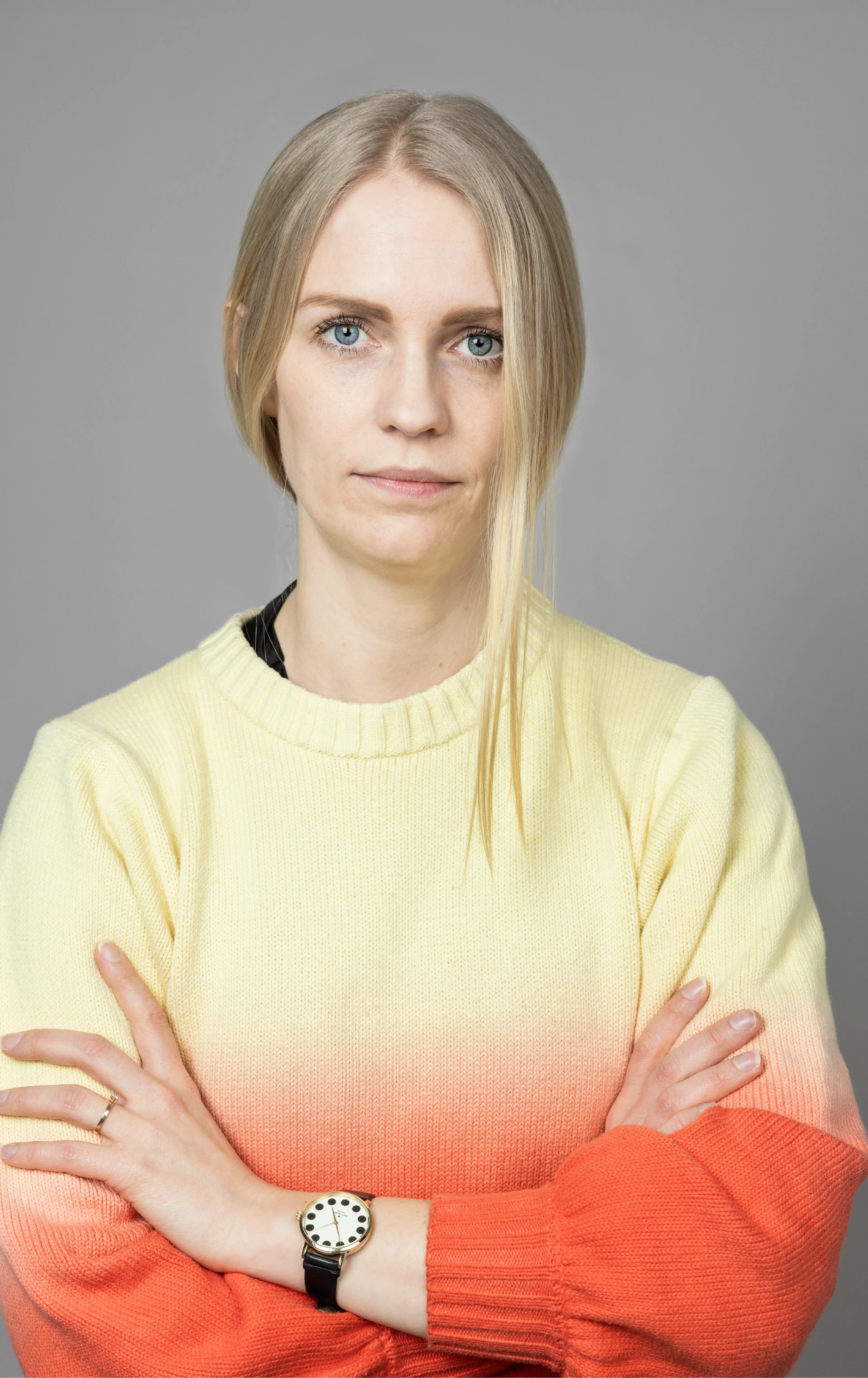 Woman in orange and yellow shirt with crossed arms