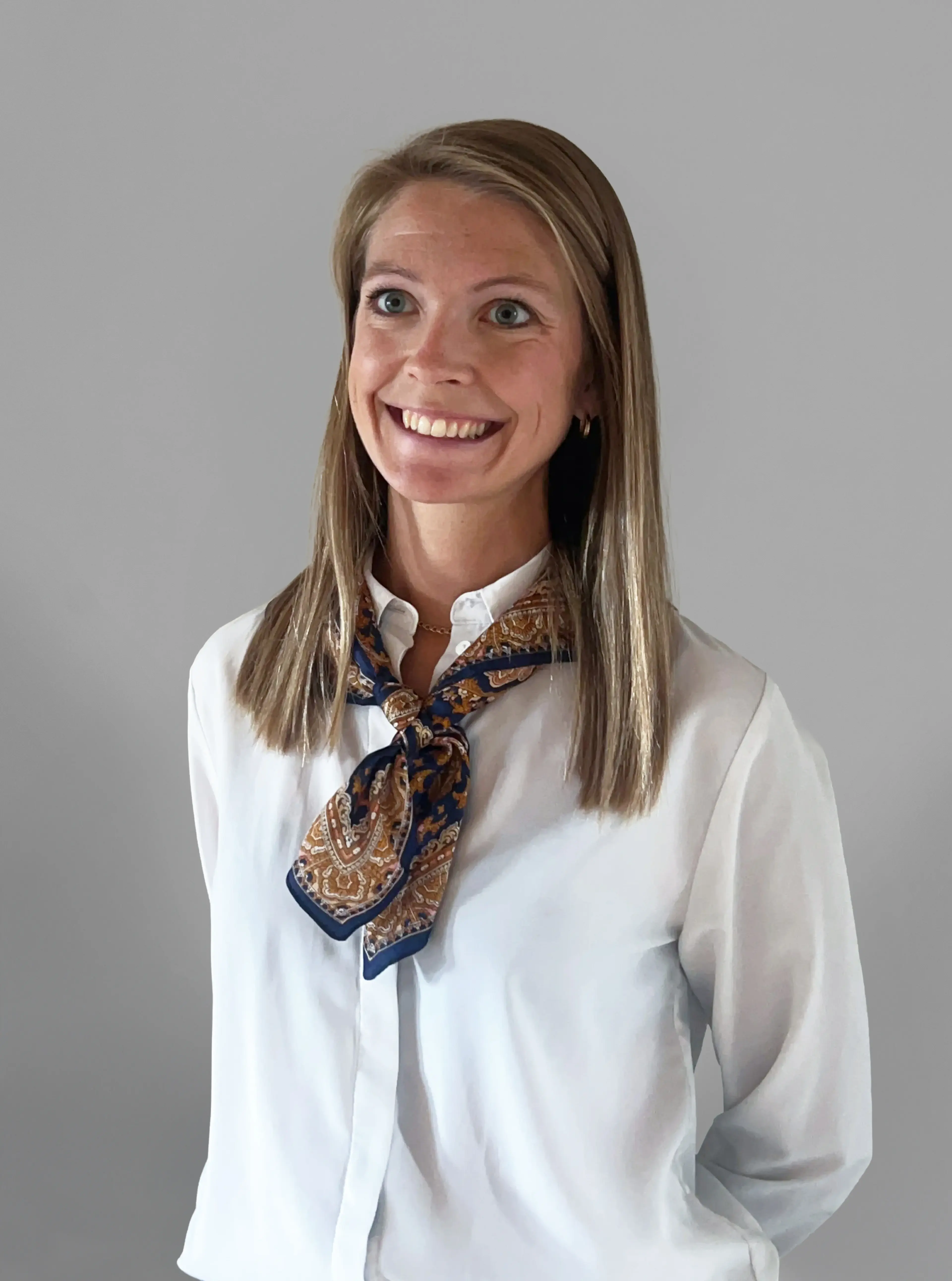 Smiling woman wearing a white shirt.