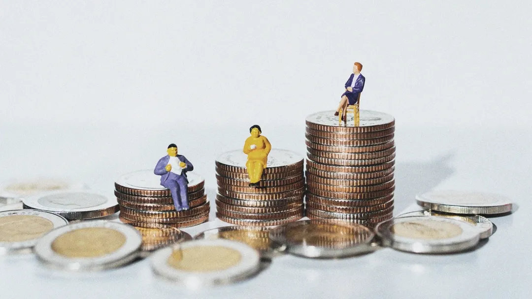 Small human figures sitting on top of piles of coins
