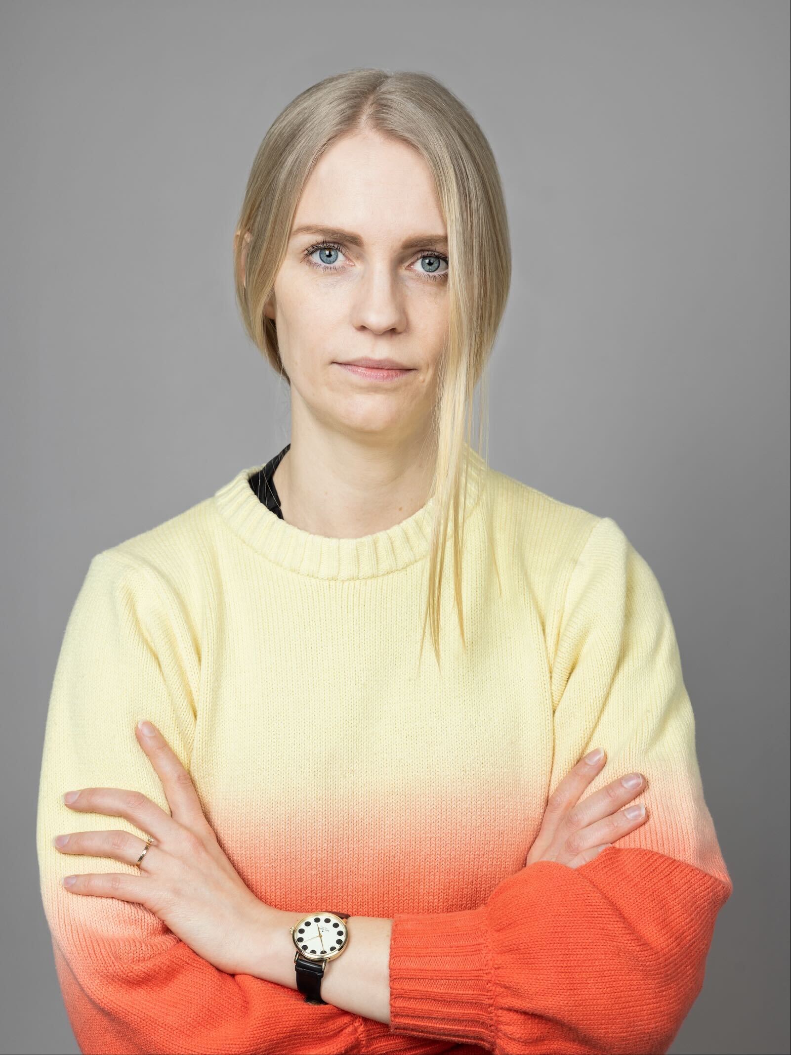 Woman in orange and yellow shirt with crossed arms