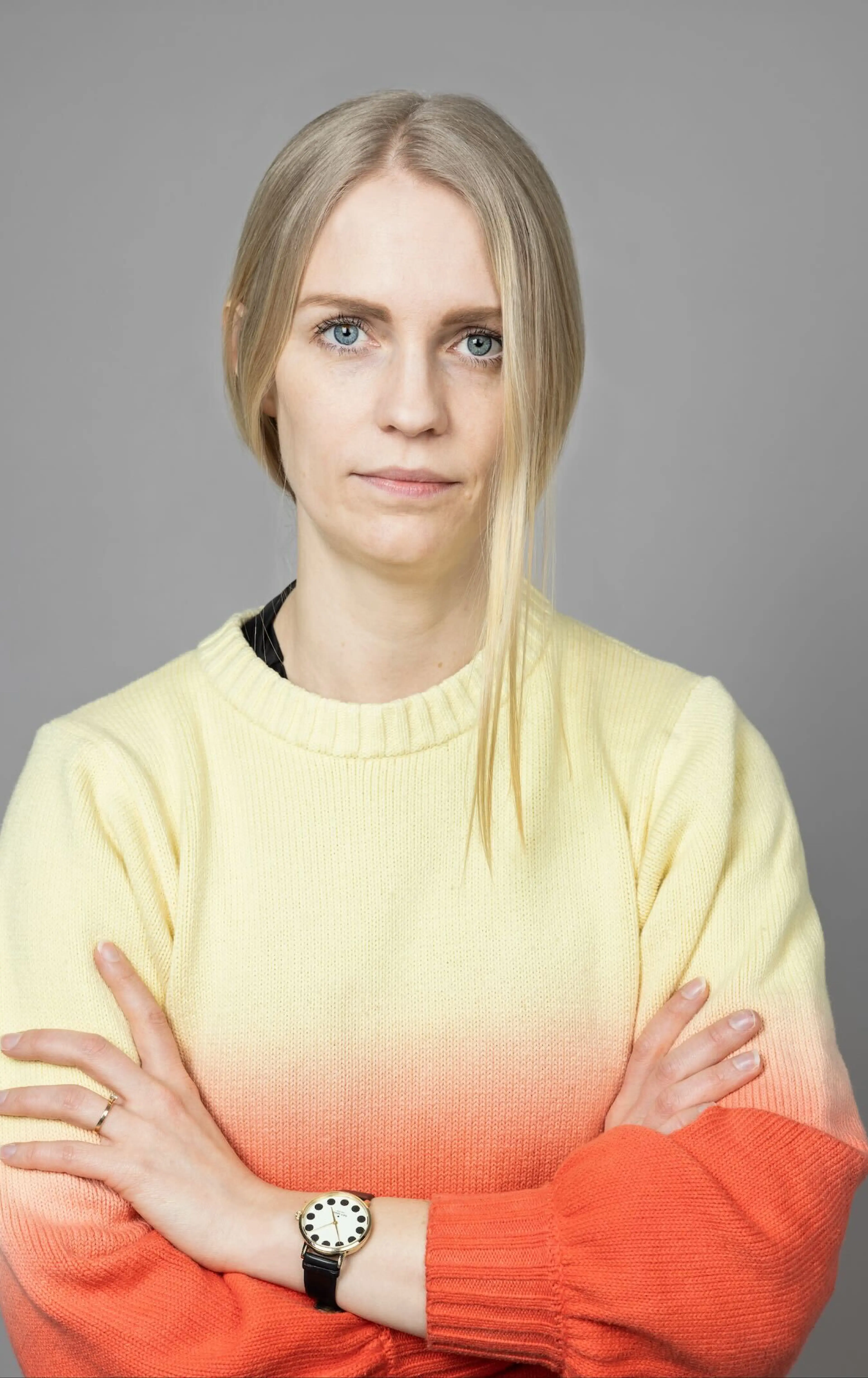 Woman in orange and yellow shirt with crossed arms