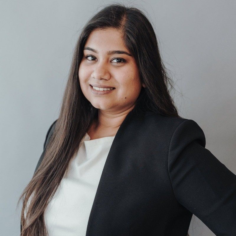 Image of female consultant wearing a black suit and white blouse