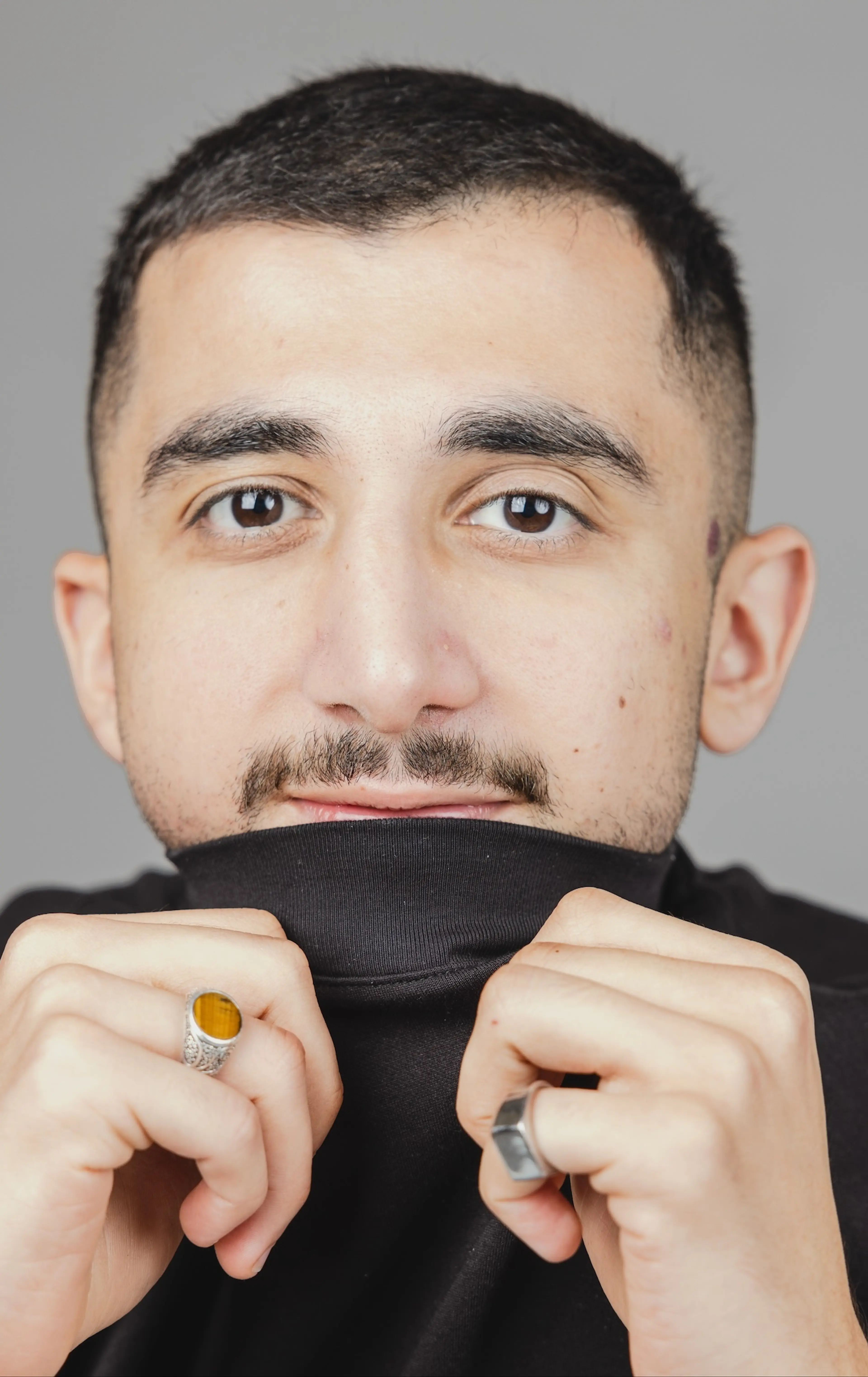 Man holding shirt over mouth