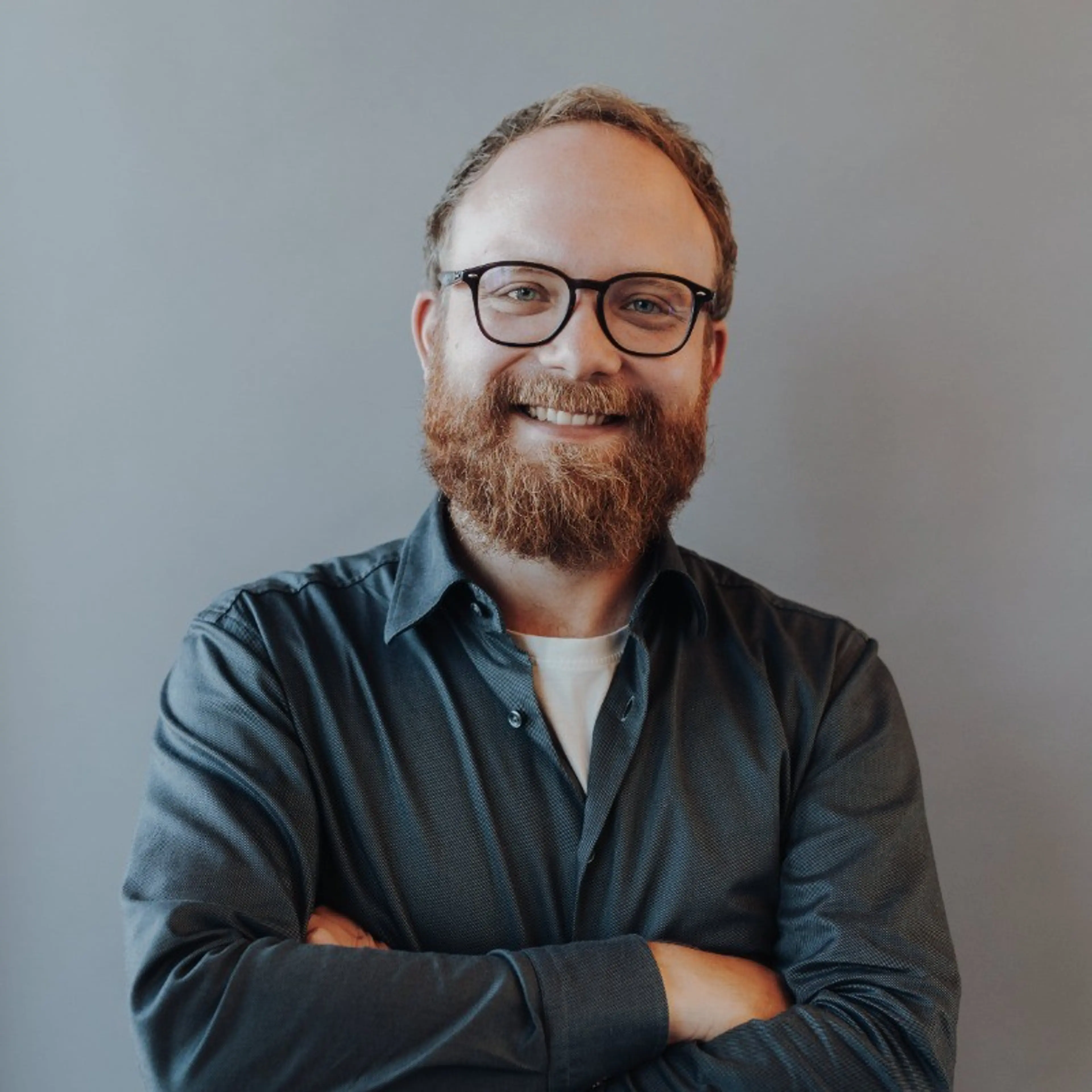 Man with glasses wears dark shirt
