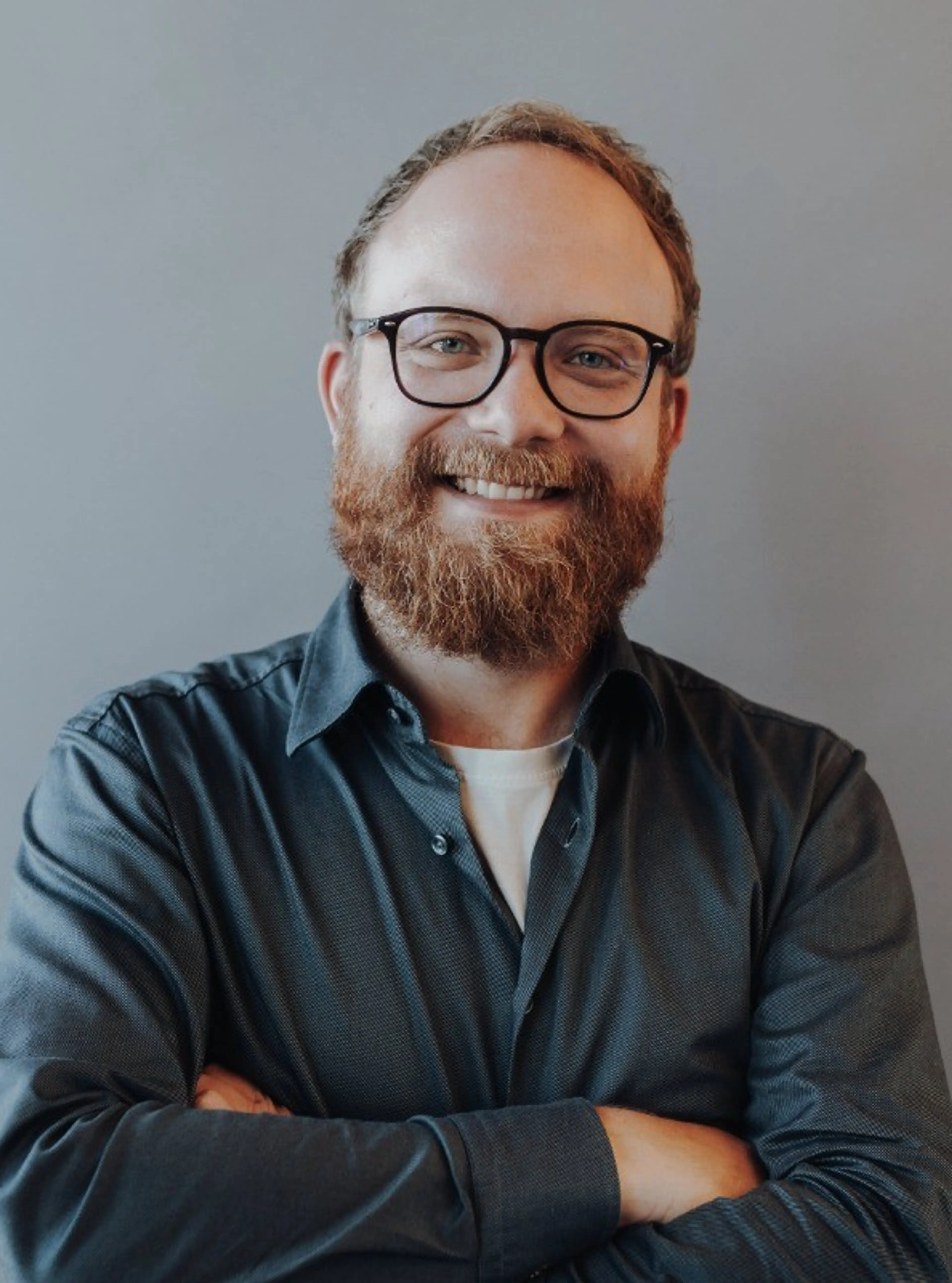 Man with glasses wears dark shirt