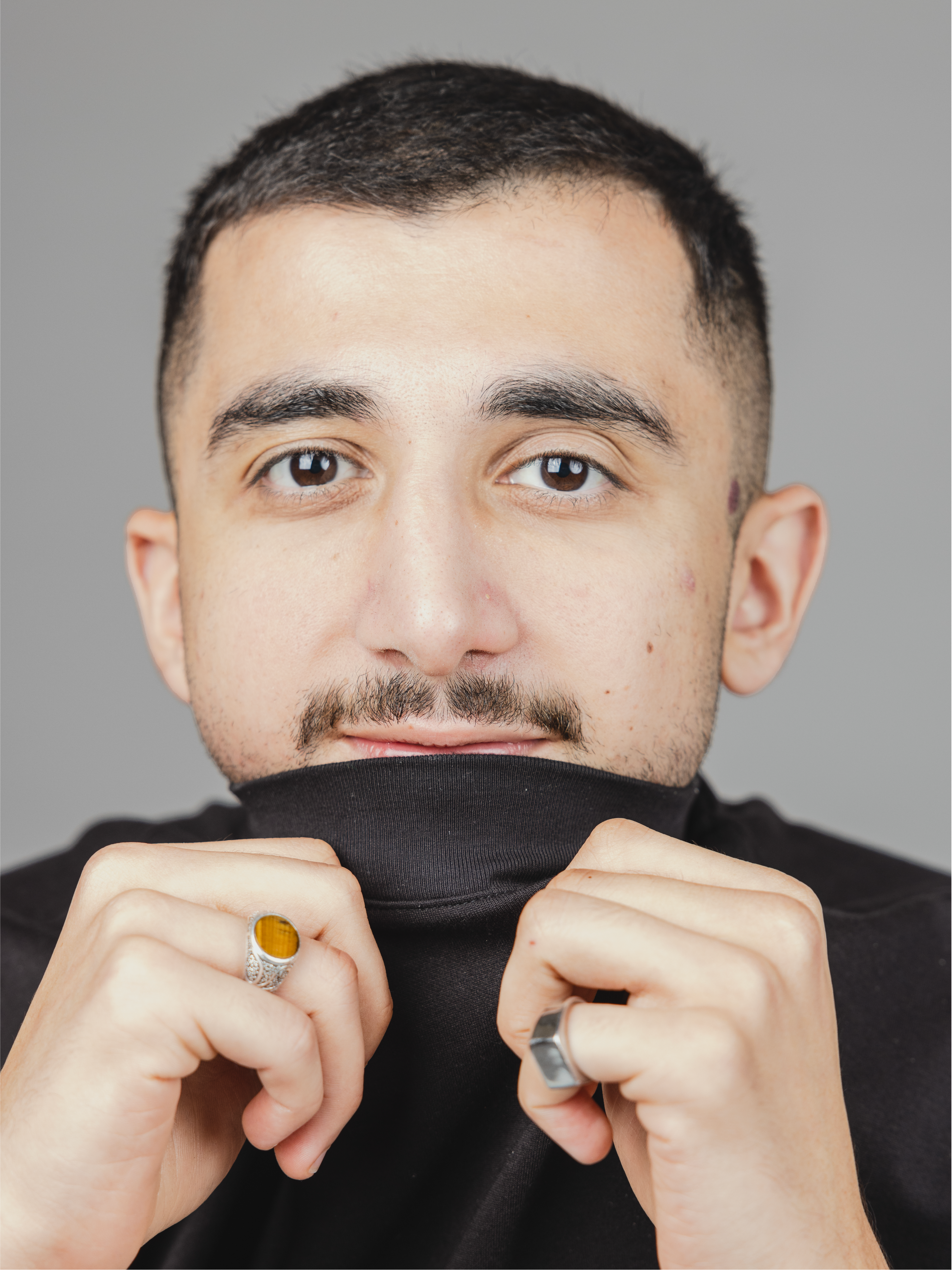 Man holding shirt over mouth