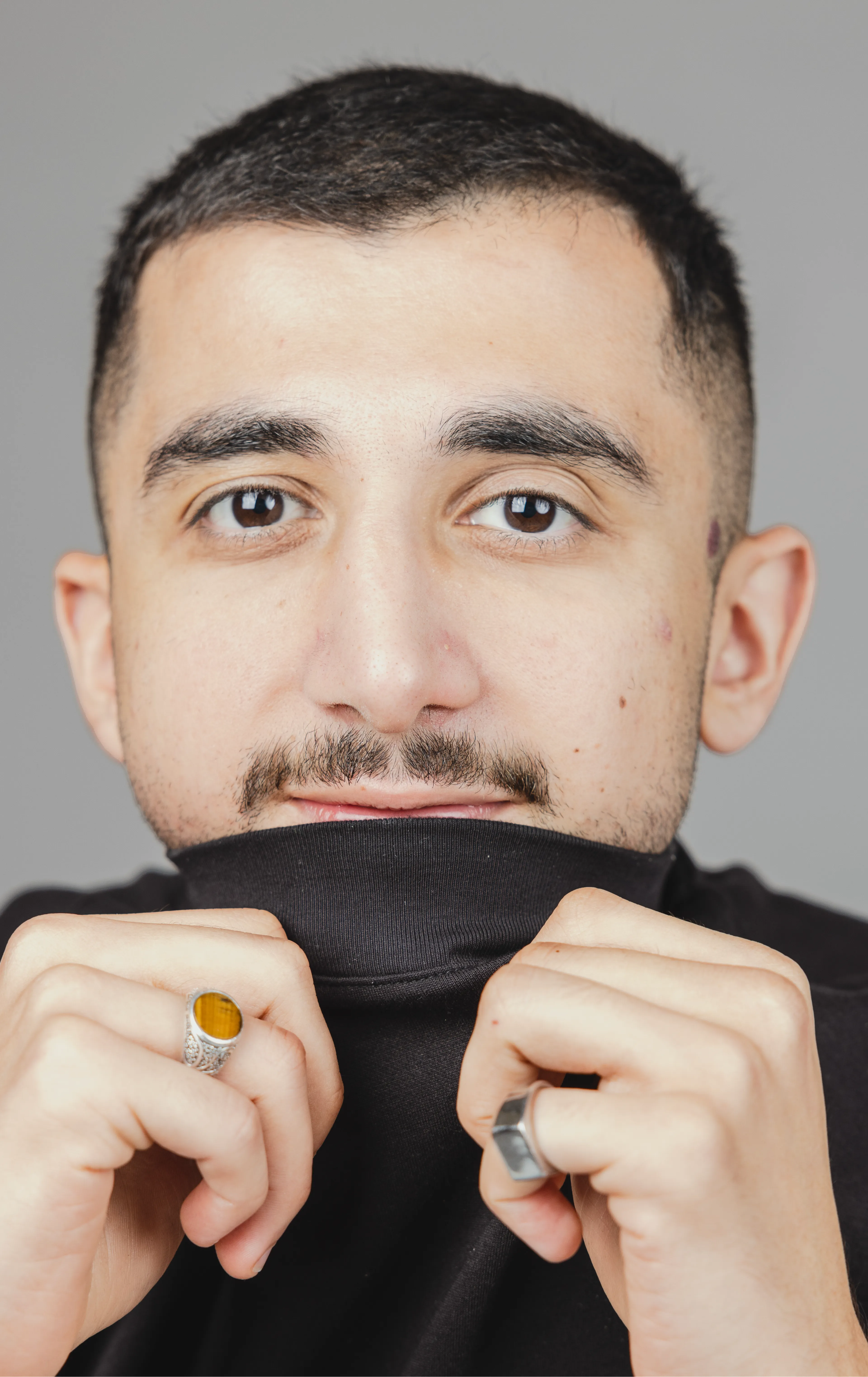 Man holding shirt over mouth