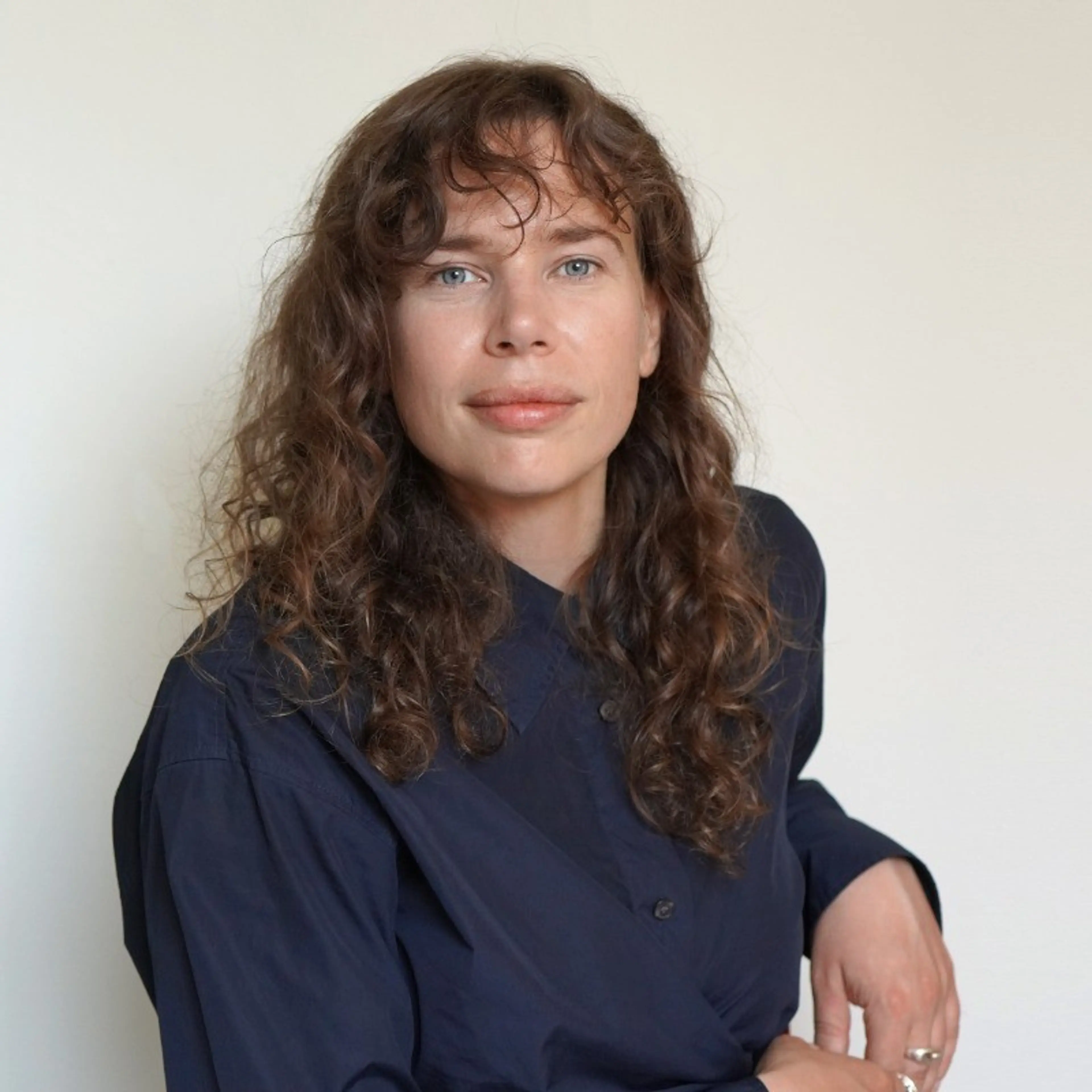 Woman with dark hair wearing a blue shirt
