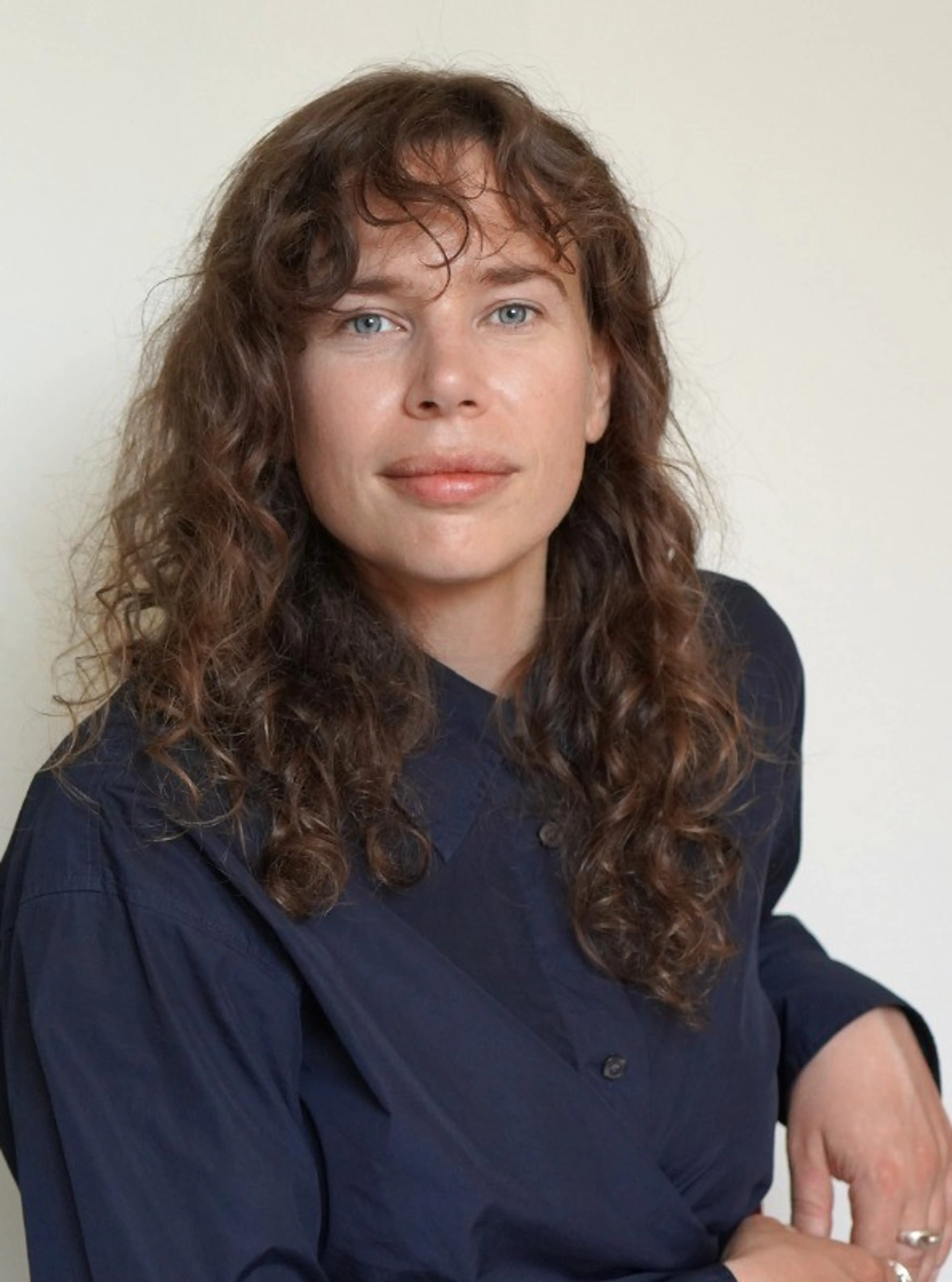Woman with dark hair wearing a blue shirt