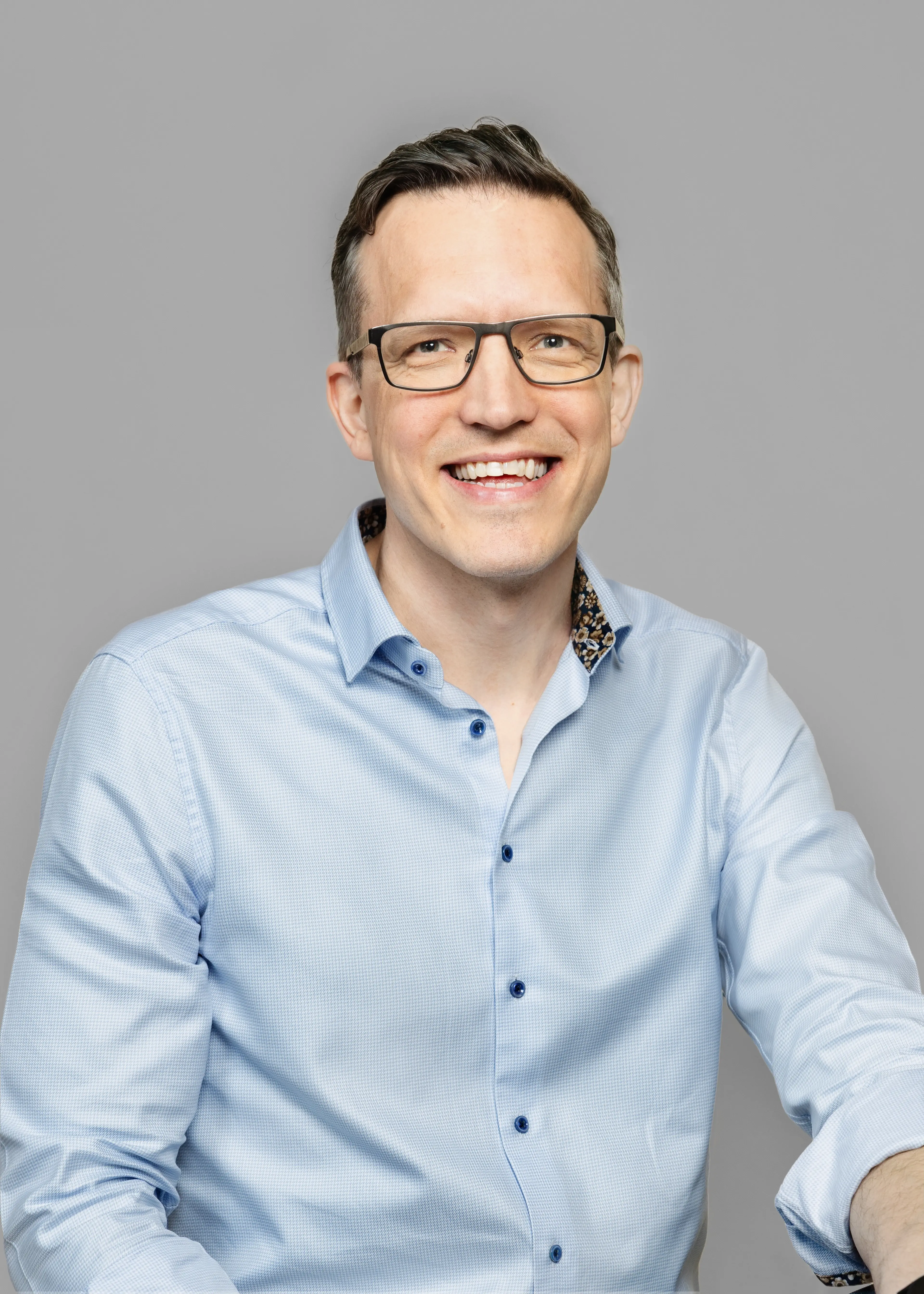 Smiling man with glasses.