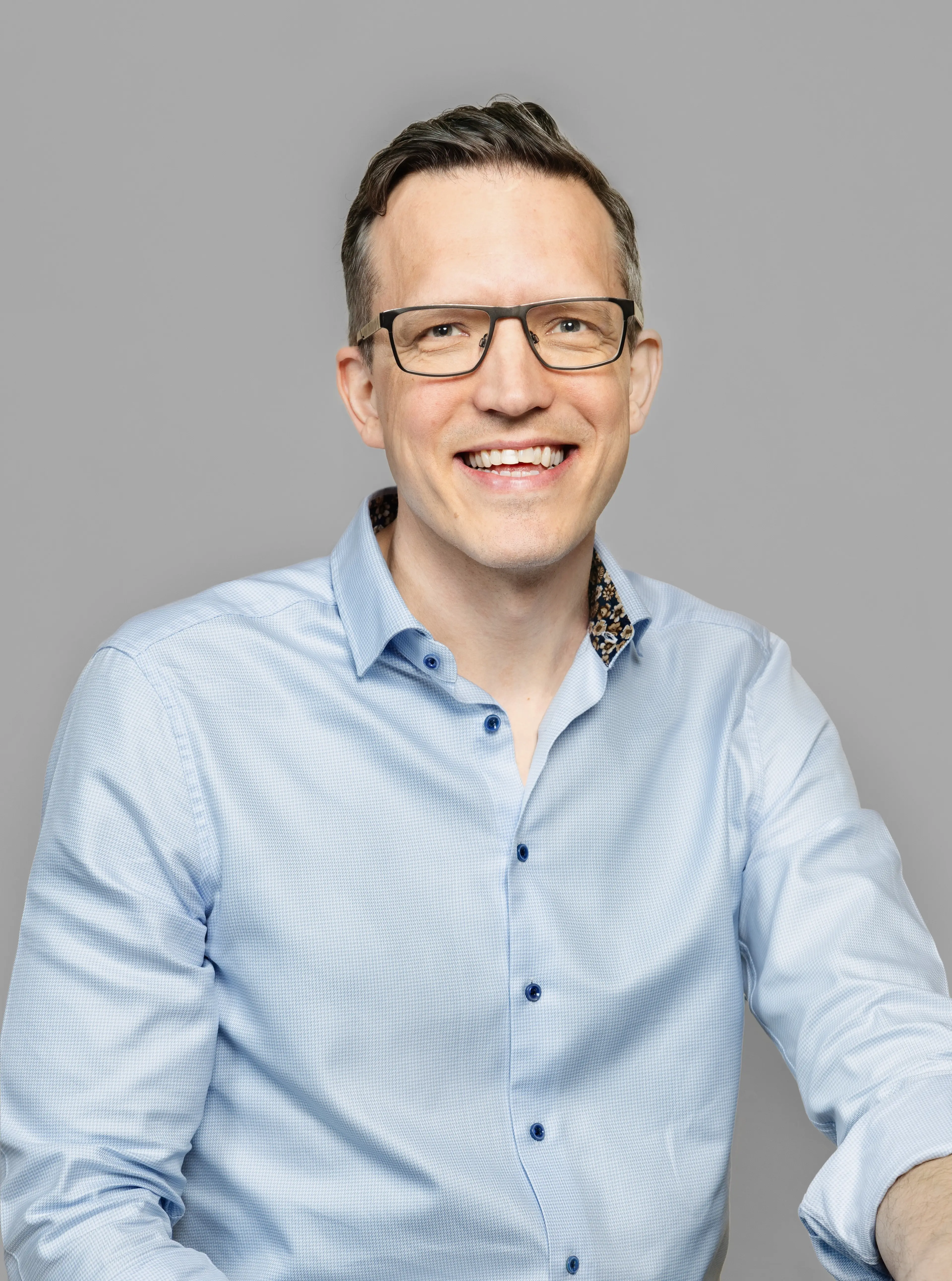 Smiling man with glasses.