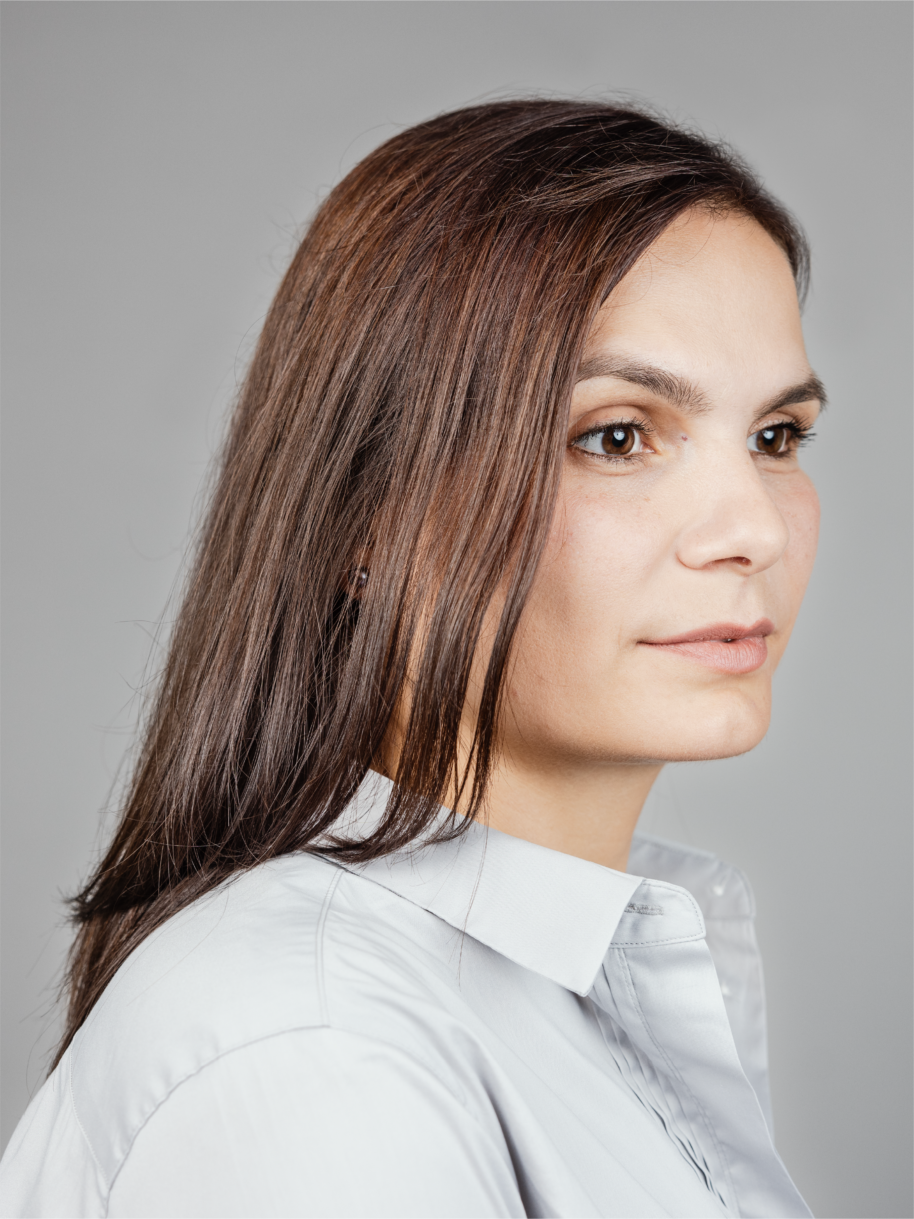 A woman with light gray shirt looking to the right