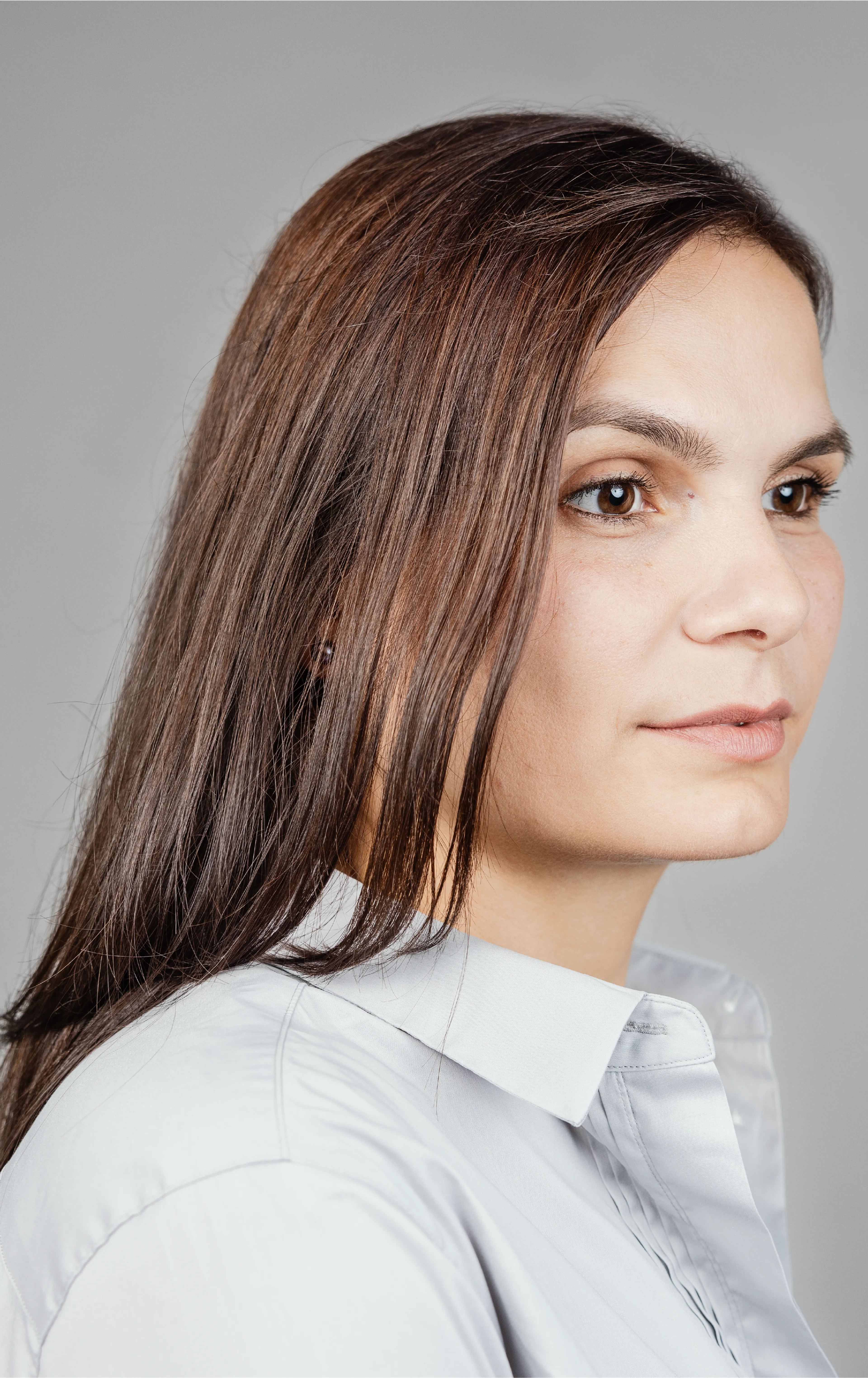 A woman with light gray shirt looking to the right