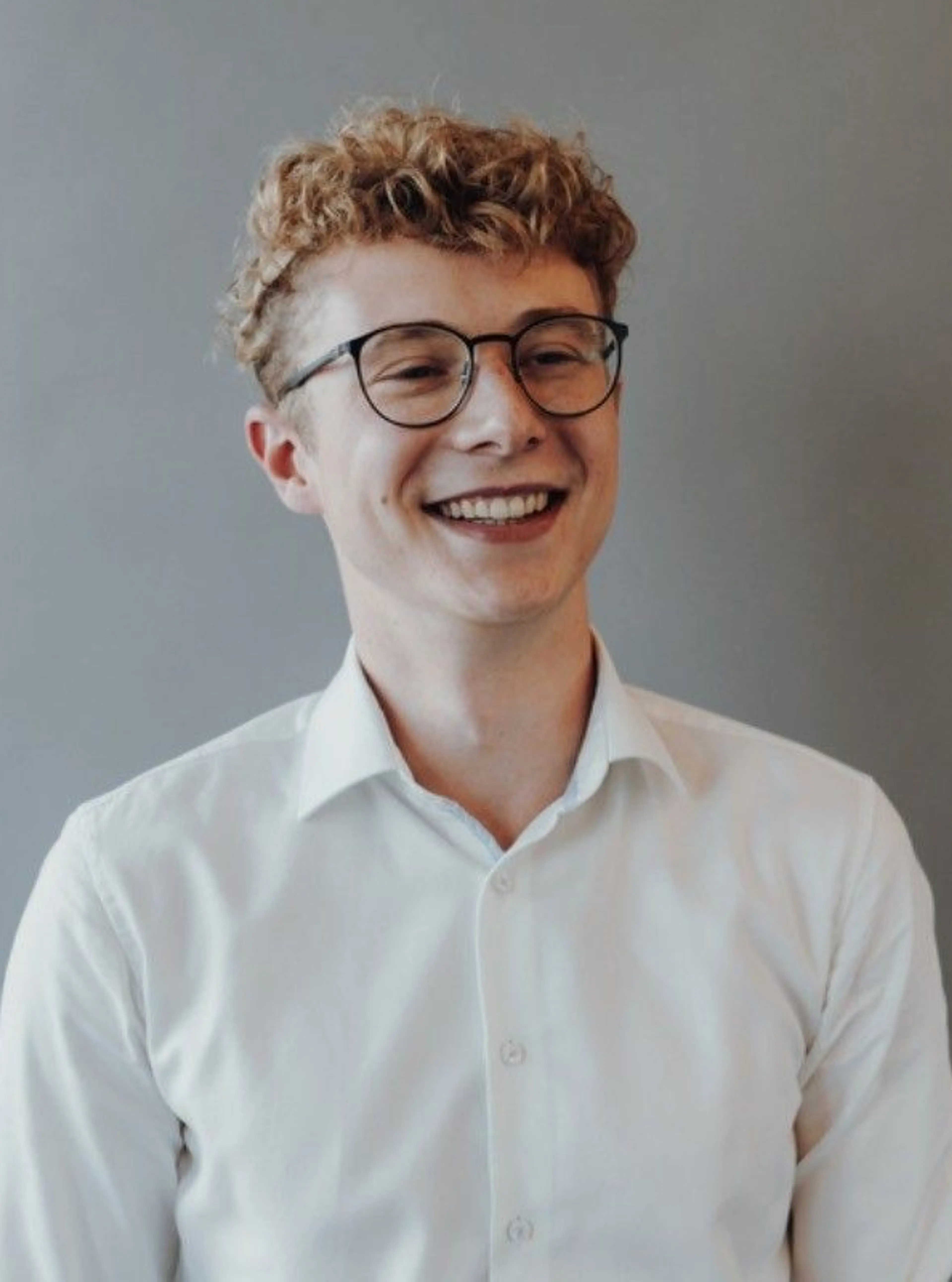 Smiling Man with glasses wearing a white shirt