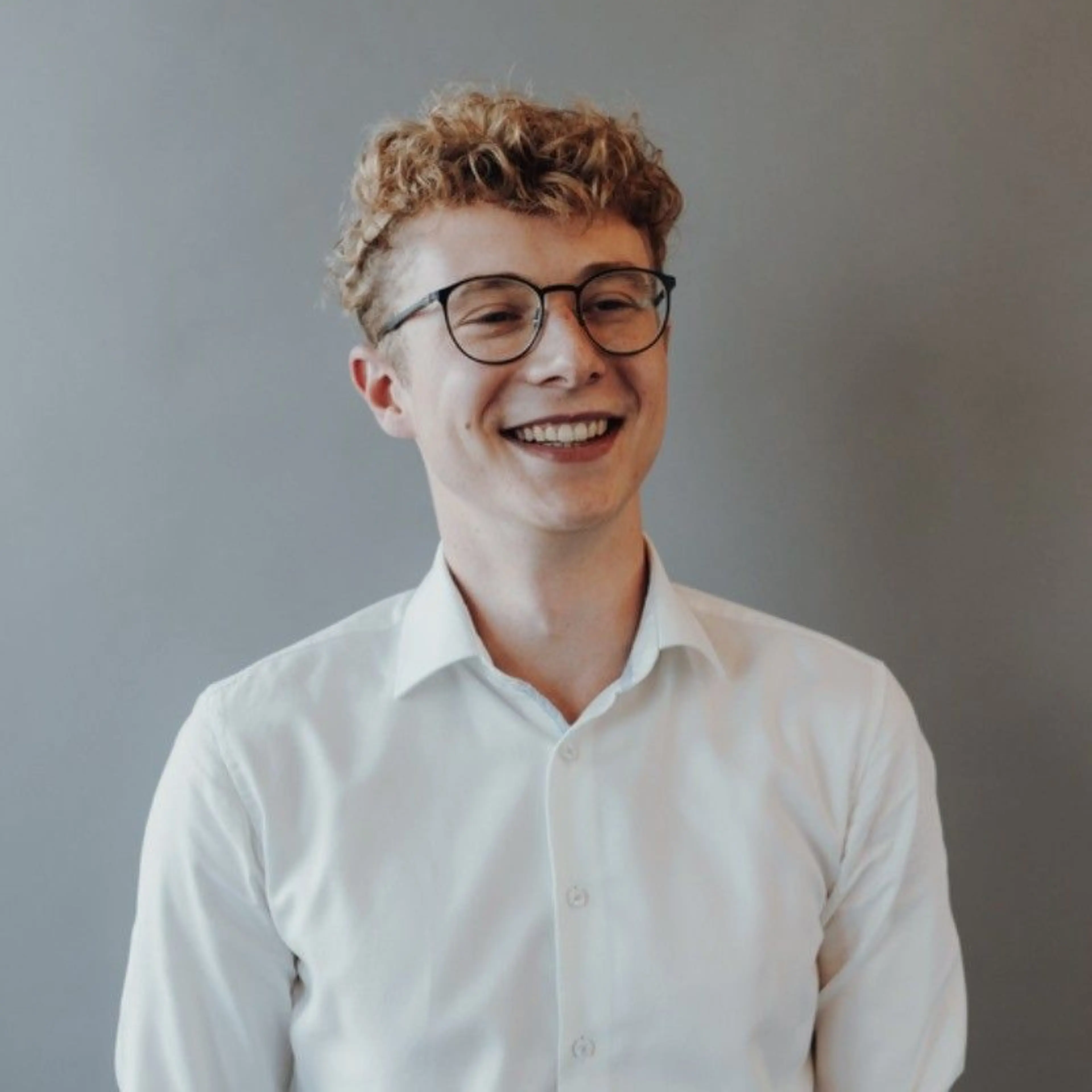 Smiling Man with glasses wearing a white shirt