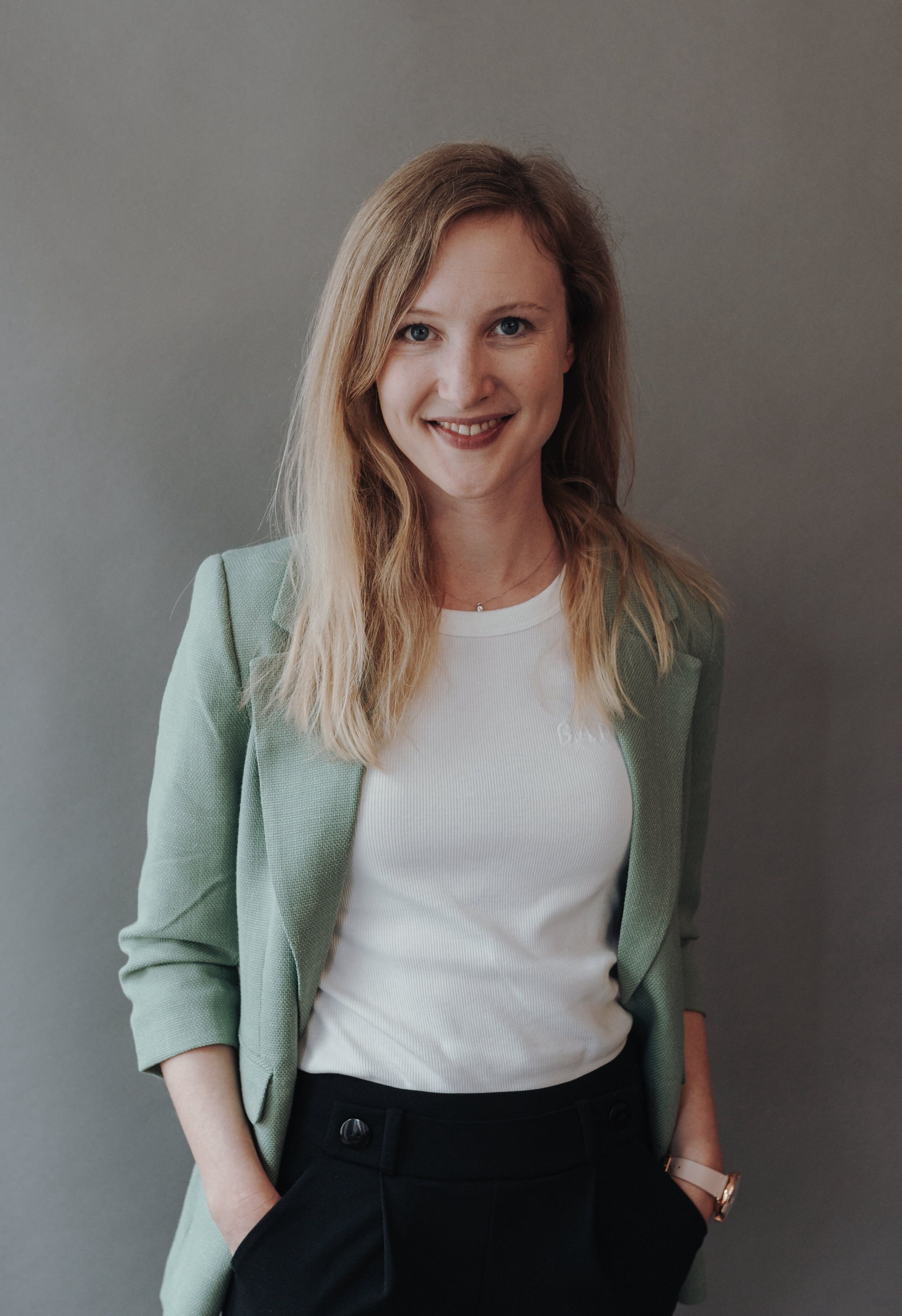 Smiling woman wearing a green blazer.