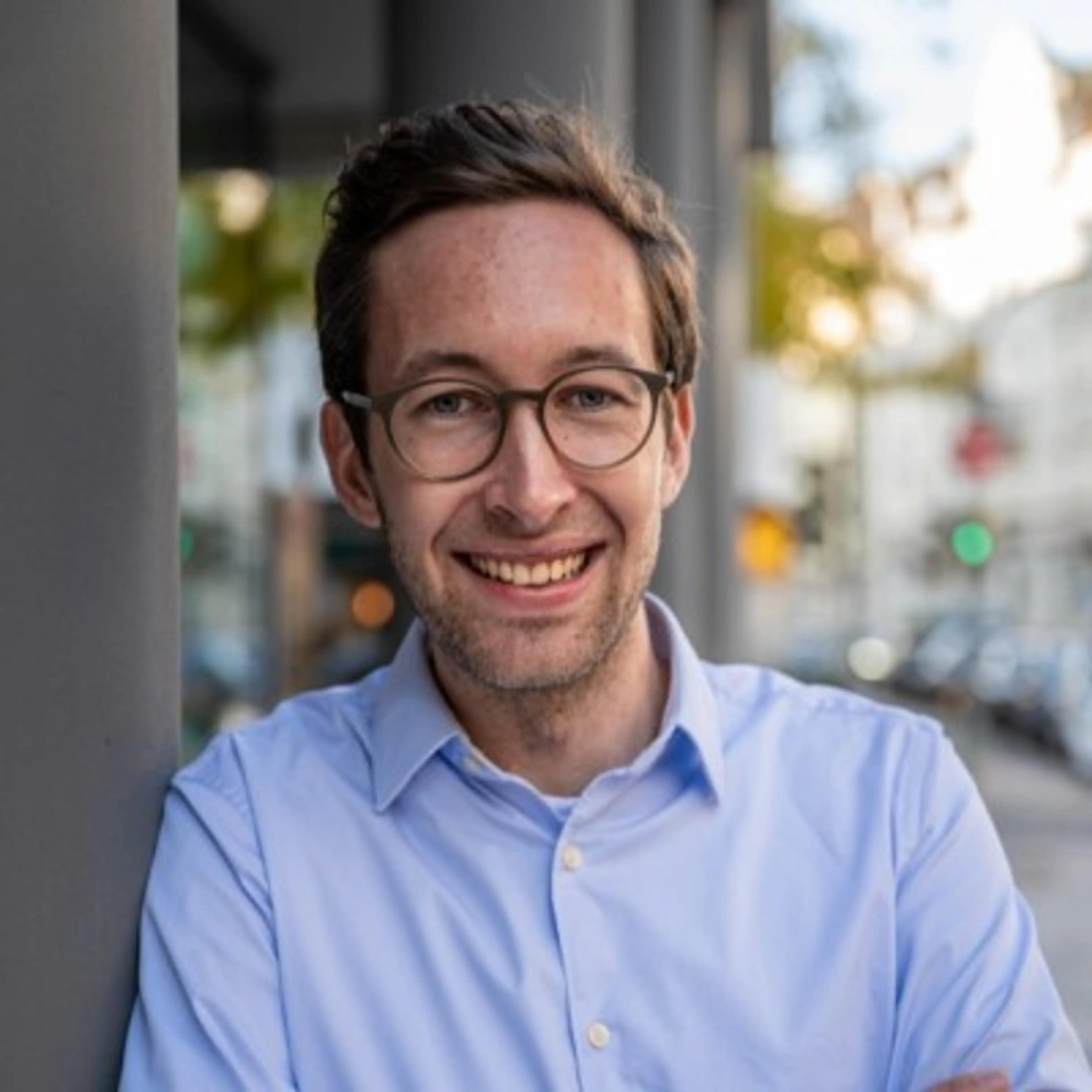 Man with glasses wearing a blue shirt.