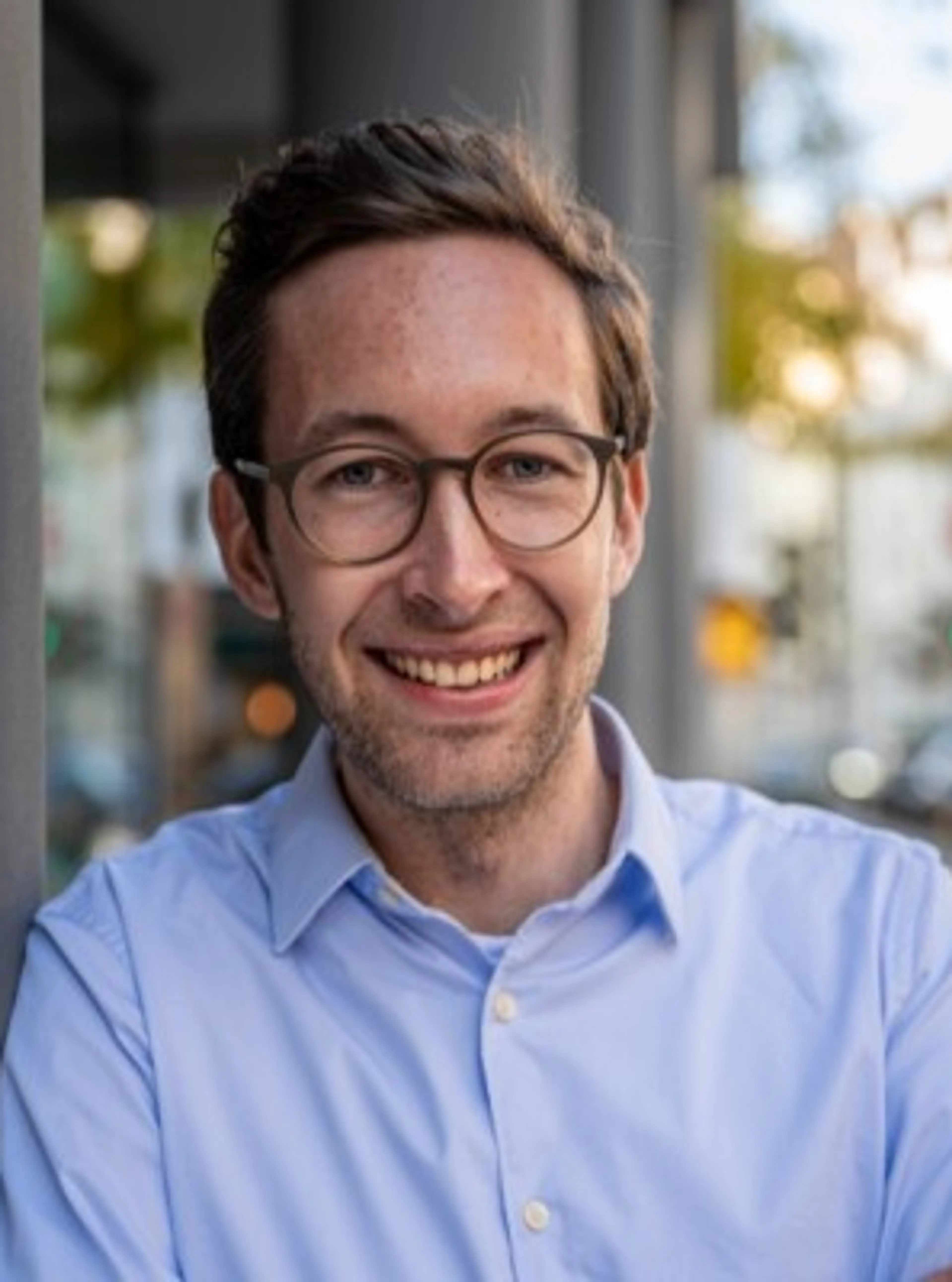 Man with glasses wearing a blue shirt.
