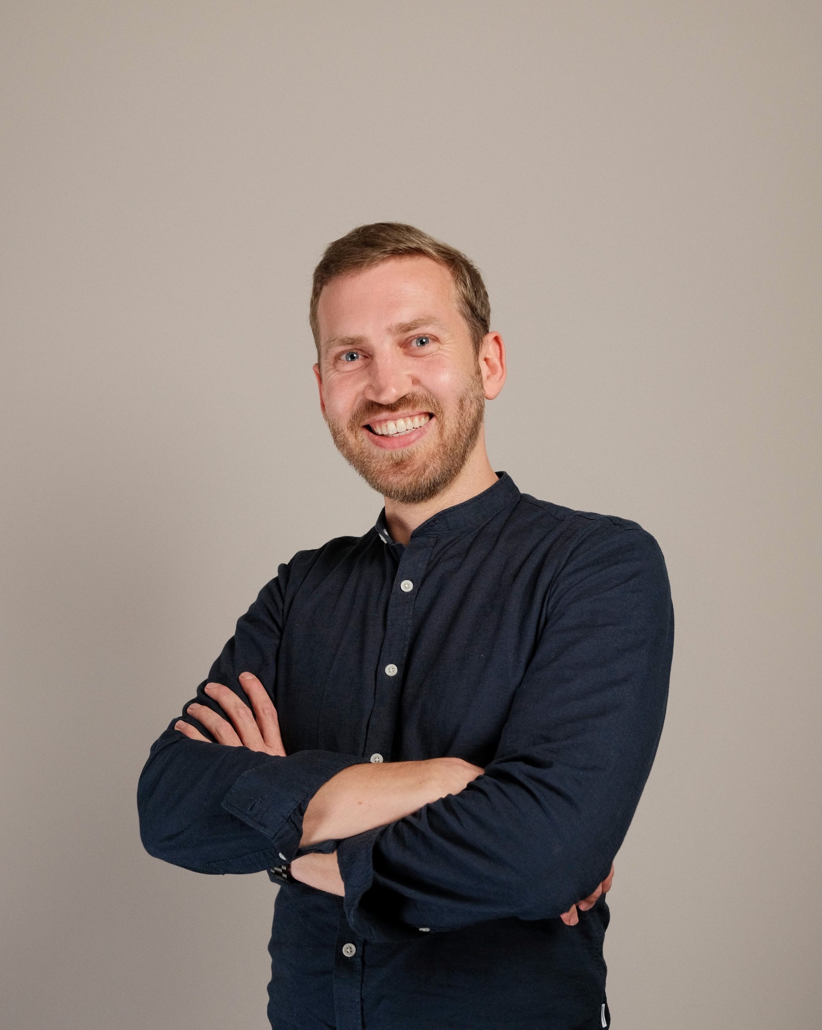 Smiling man wearing a blue shirt.