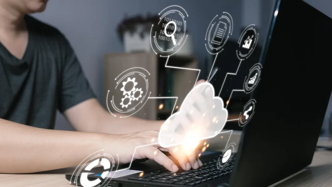 : Person typing on a laptop keyboard with digital application and cloud computing icons overlaid, representing concepts such as technology integration, software, and online connectivity