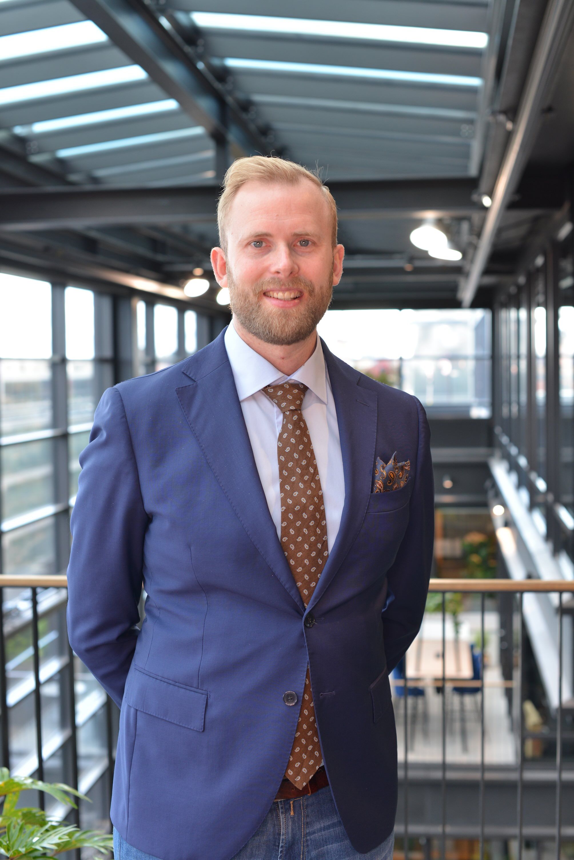 Blonde man wearing a blue suit and a tie