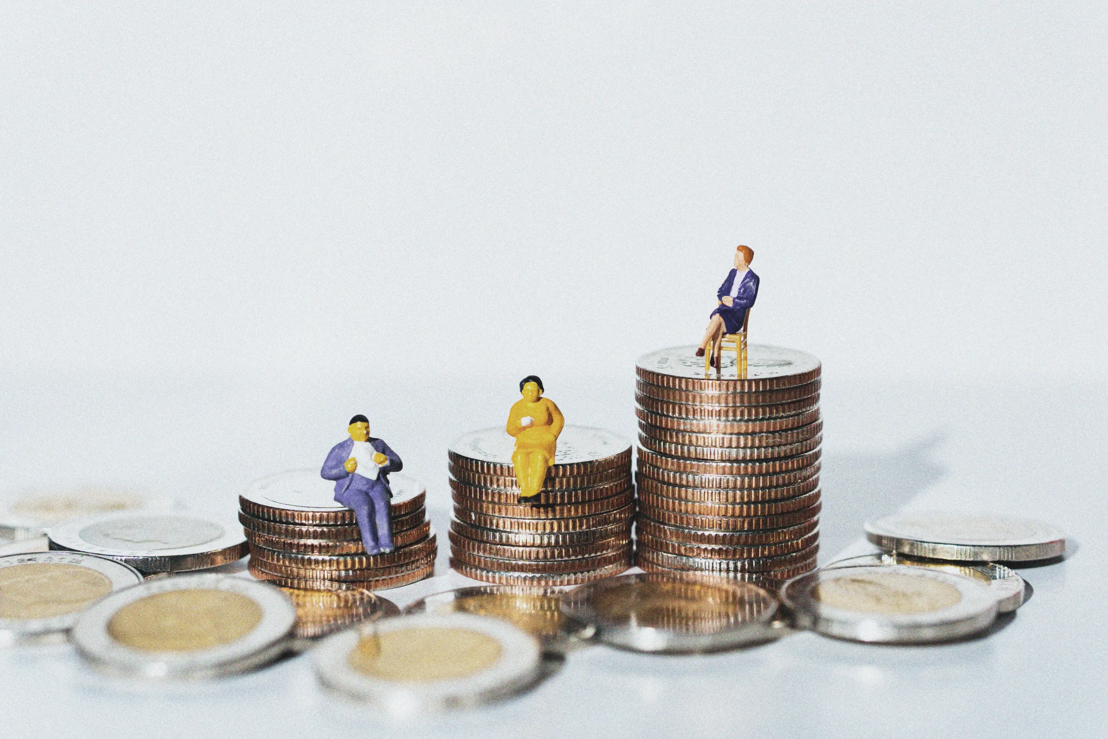 Small human figures on pile on coins.