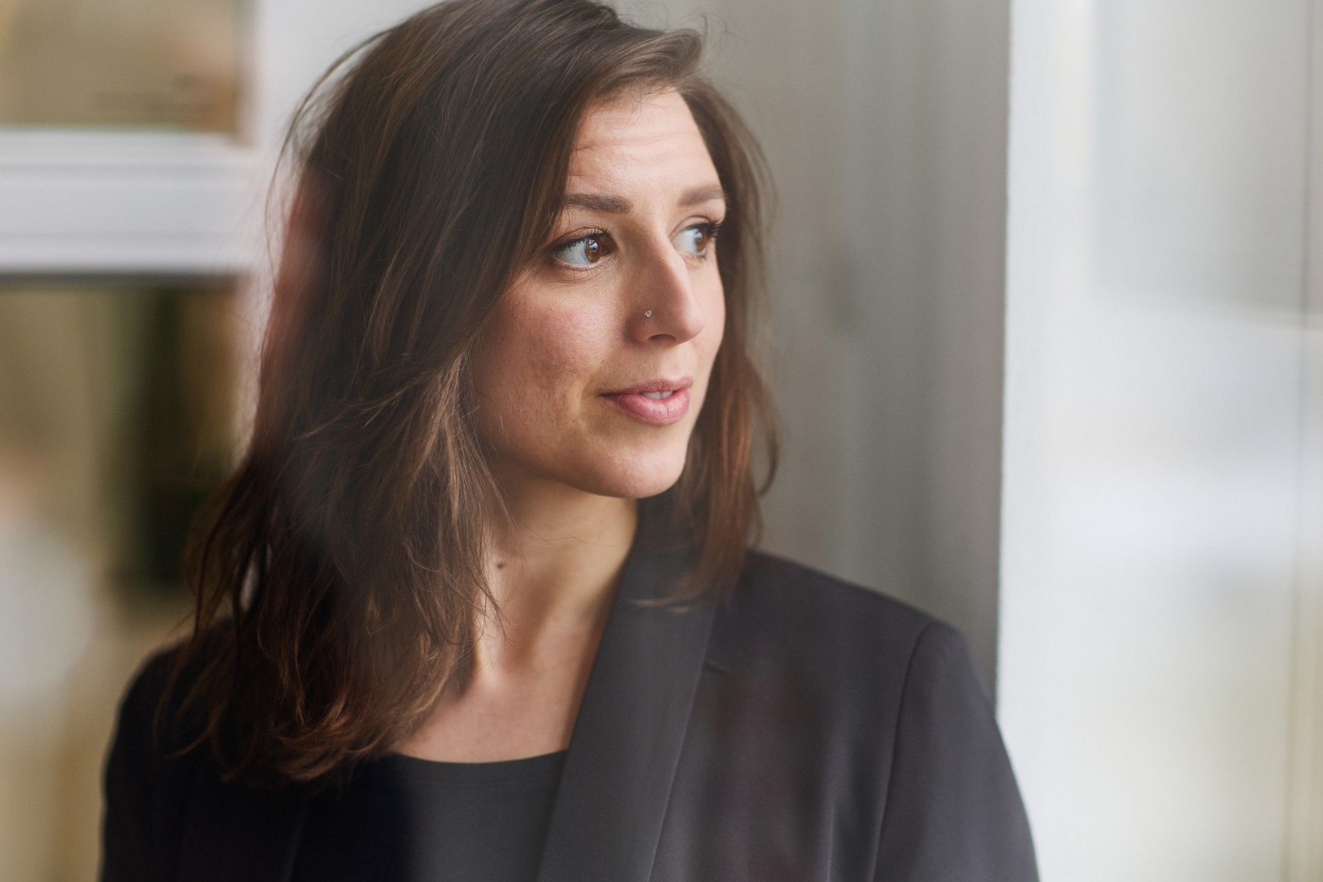 Woman wearing a black shirt and looking to the side.