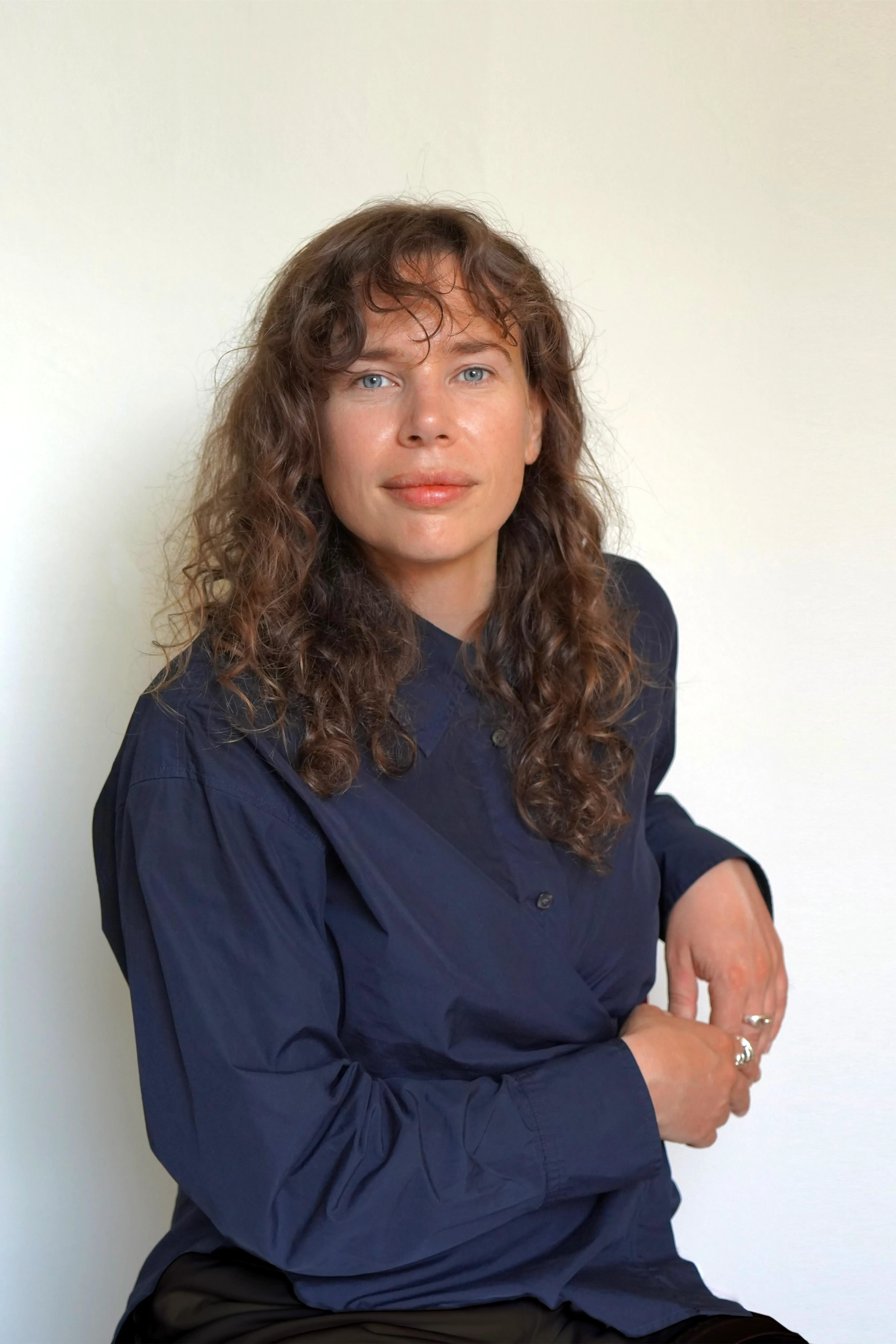 Woman with dark hair wearing a blue shirt