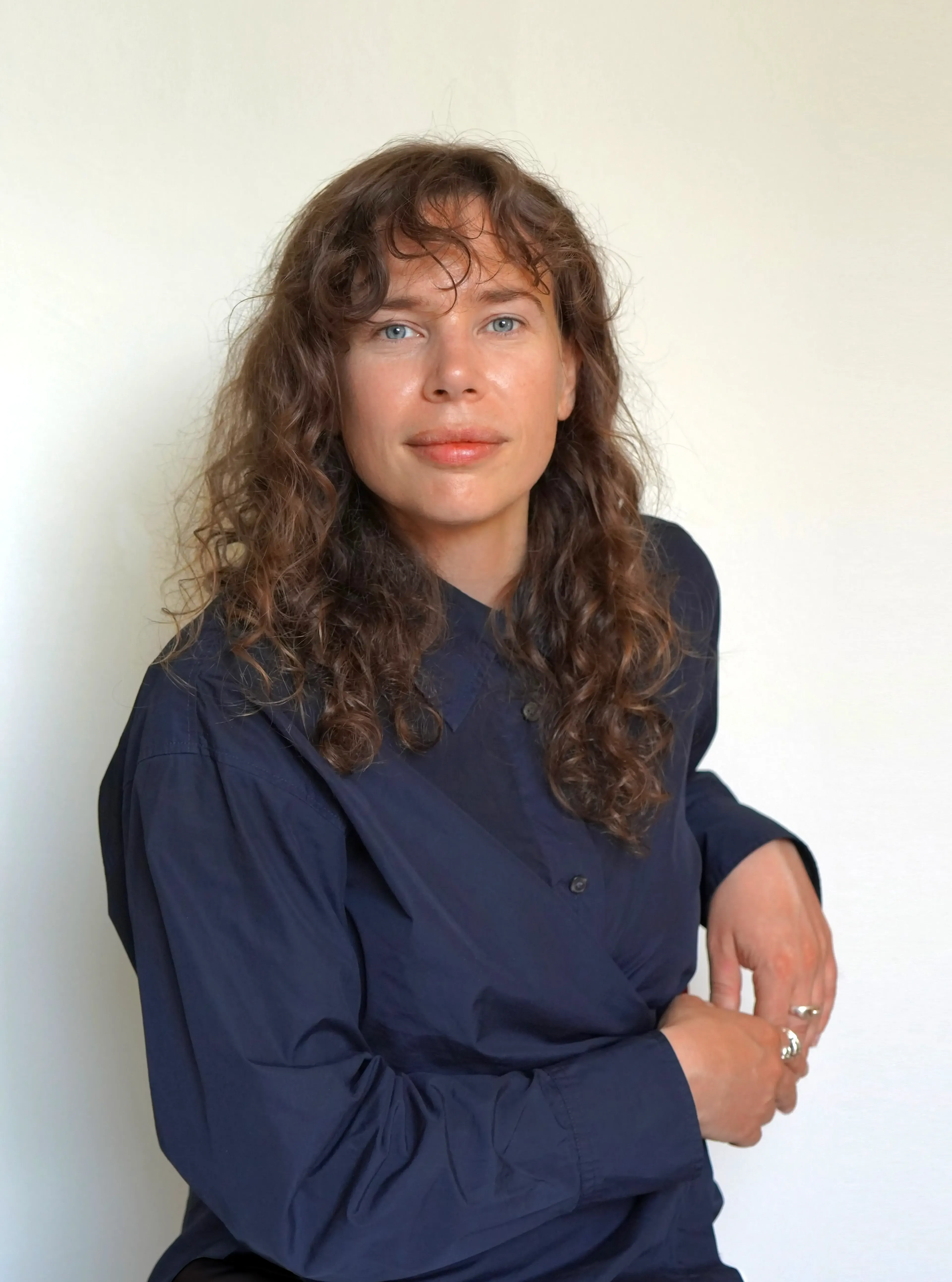 Woman with dark hair wearing a blue shirt